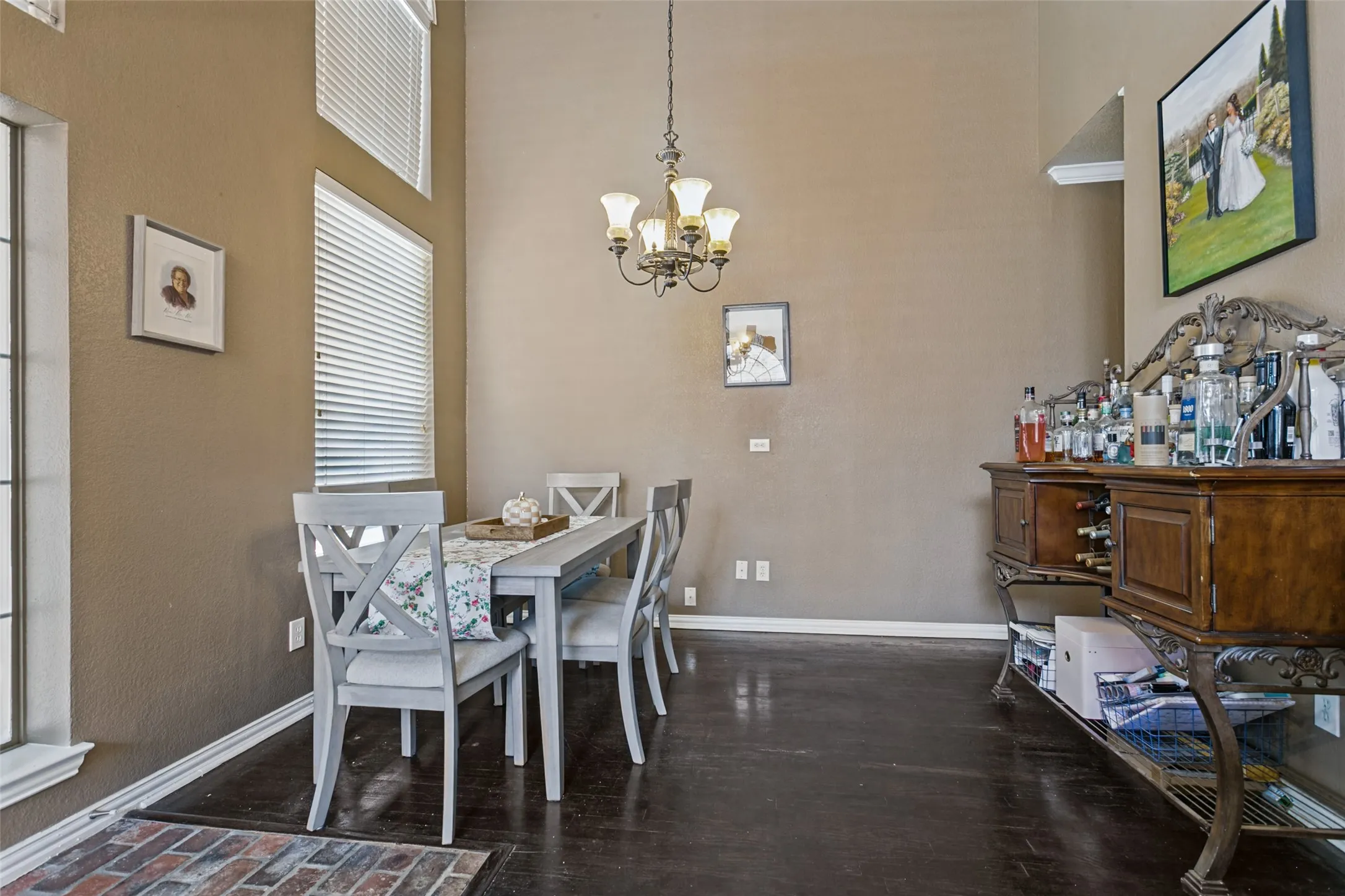 Recessed ceiling, chandelier lighting, high ceilings, wood-finish flooring, multiple windows