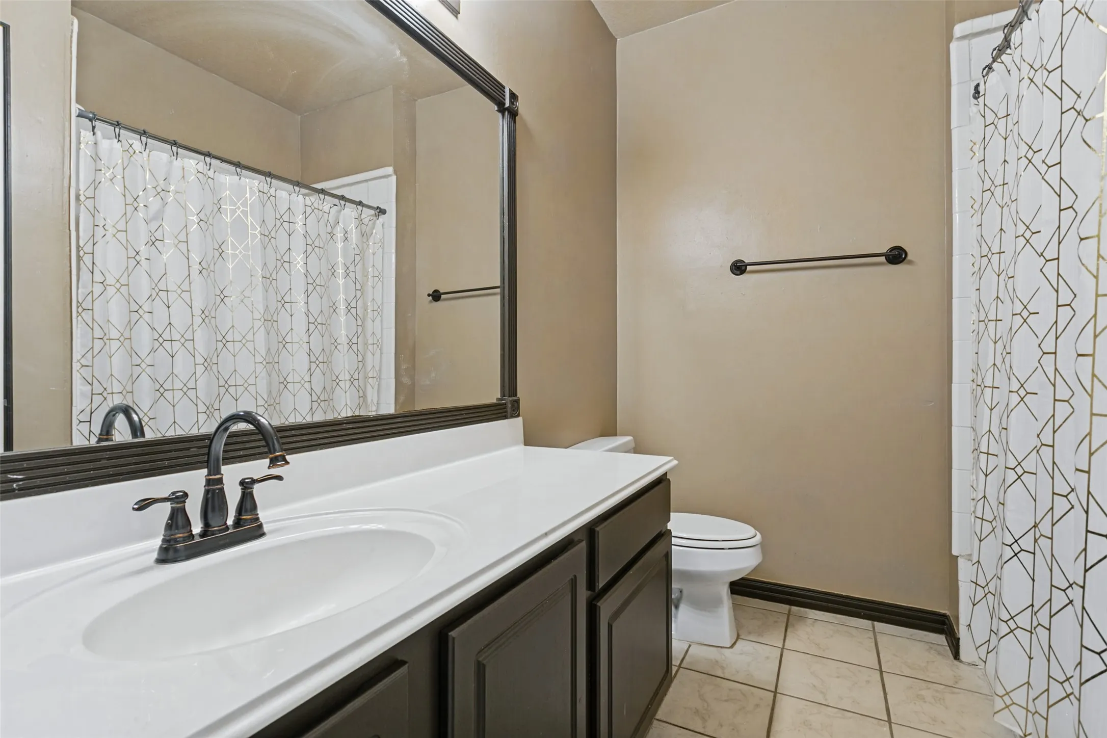 White countertop with integrated sink and dark bronze faucet