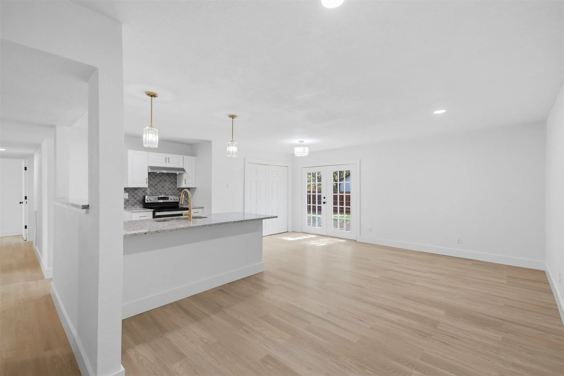 Bright open-concept interior featuring light wood-finish flooring