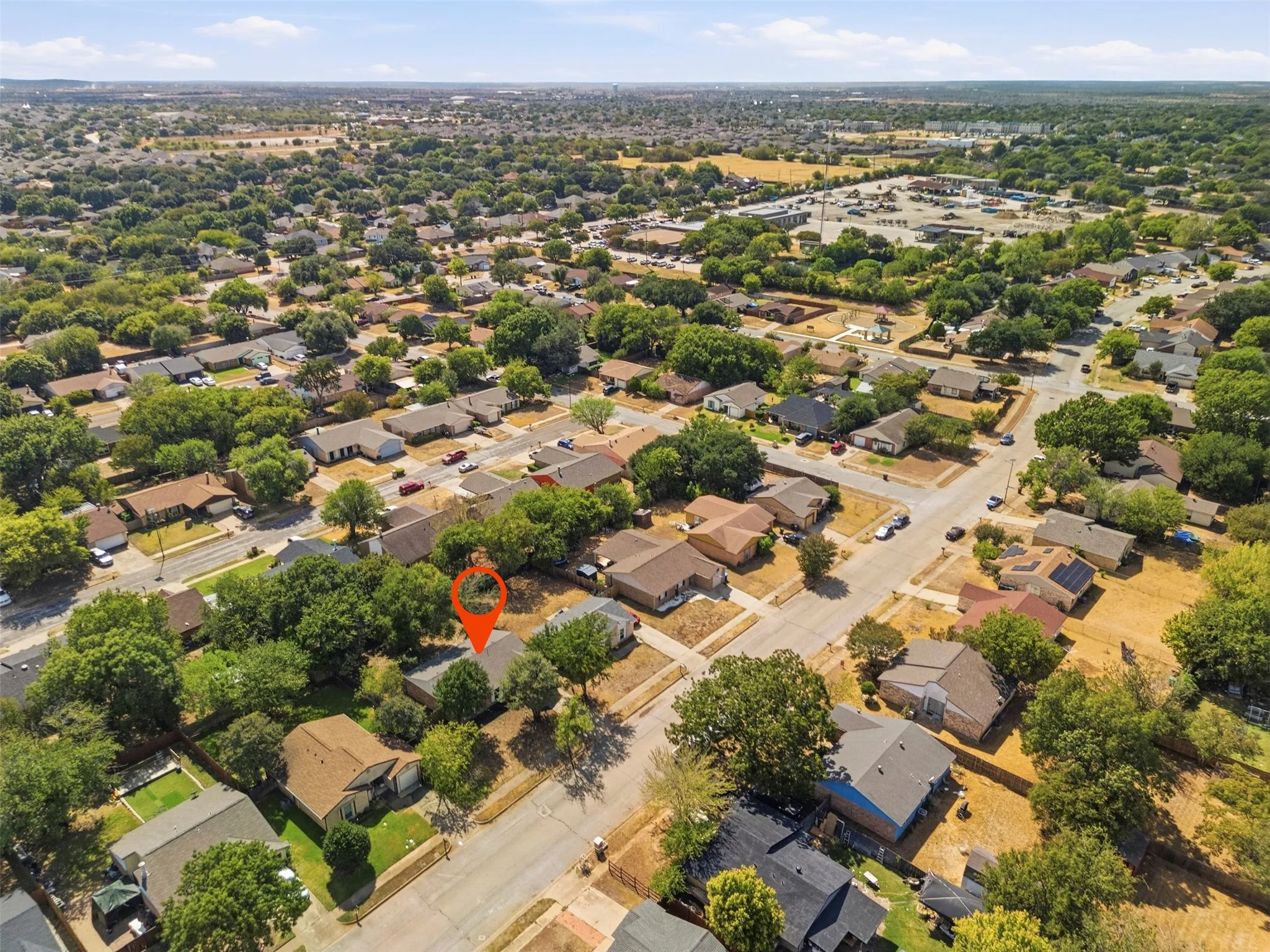 Aerial perspective of a residential neighborhood with mature trees and a dense layout