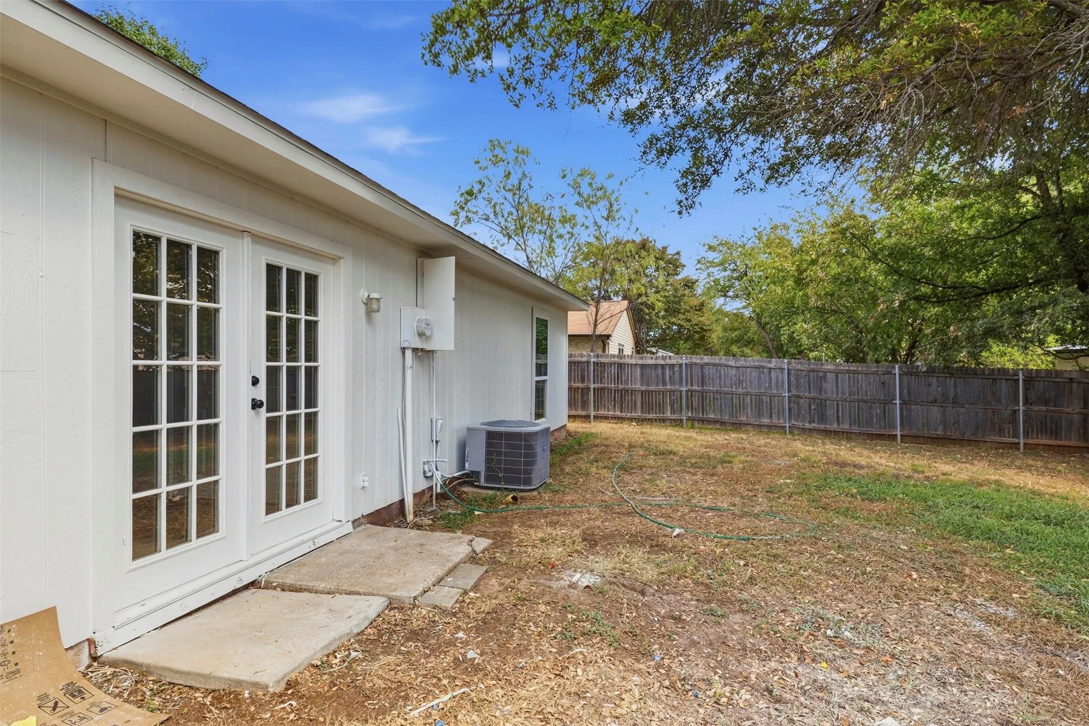 Backyard space with wood fence and mature trees