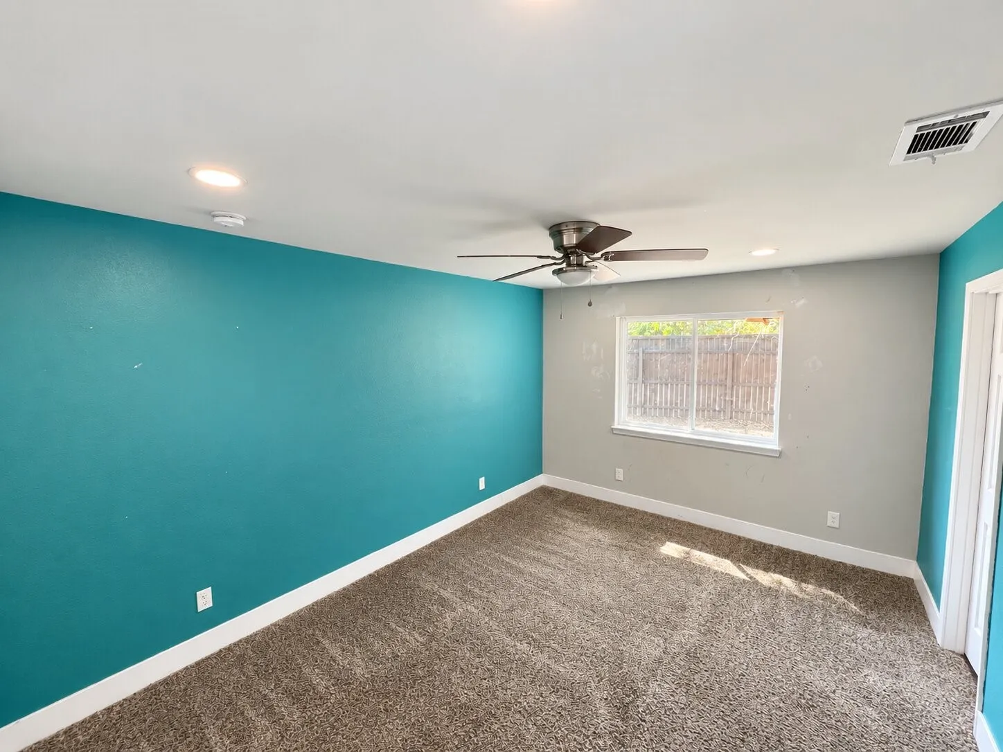 Recessed ceiling lighting, ceiling fan, window with white trim, and carpet flooring