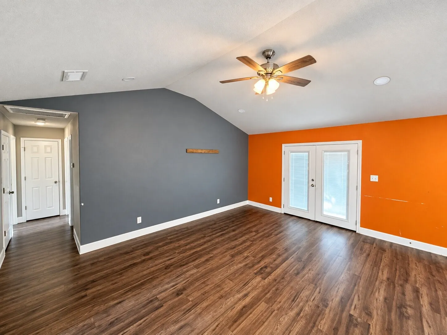 Vaulted ceiling with a ceiling fan, wood-finish flooring, recessed lighting, and double French doors with integrated blinds