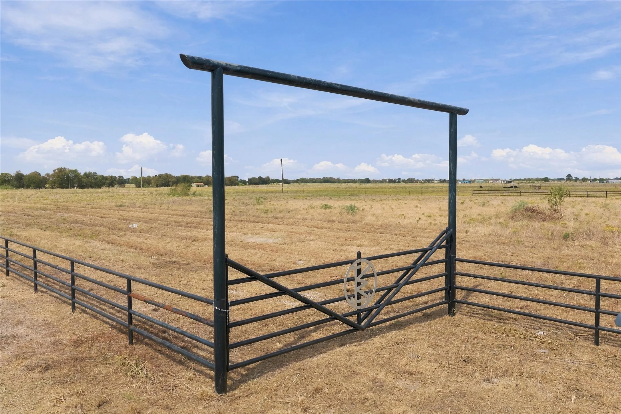 Wrought iron gate entry with decorative wagon wheel accent
