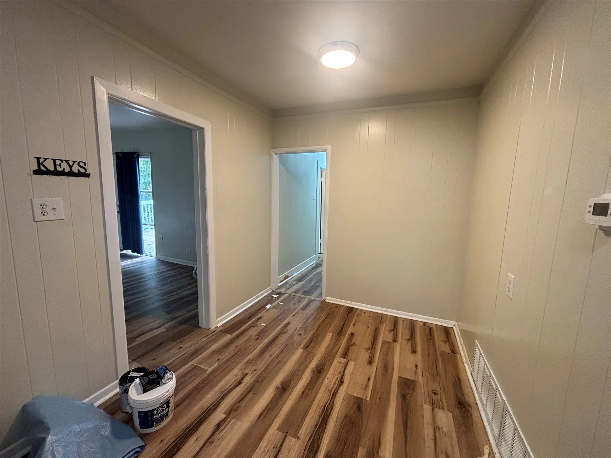 Wood-finish flooring throughout, complemented by panel walls and white trim