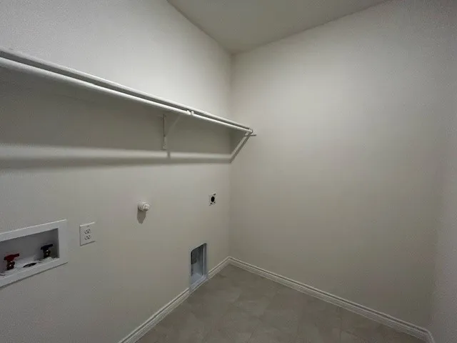 Clothes washing area featuring hookup for a gas dryer, hookup for an electric dryer, and washer hookup