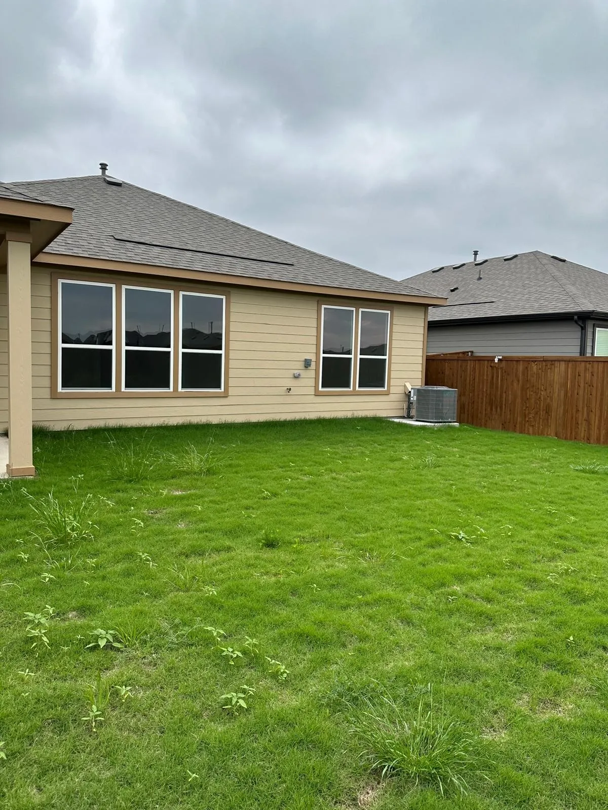 Back of house with a lawn and central air condition unit