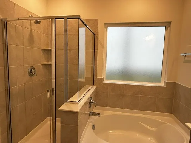Bathroom featuring shower with separate bathtub