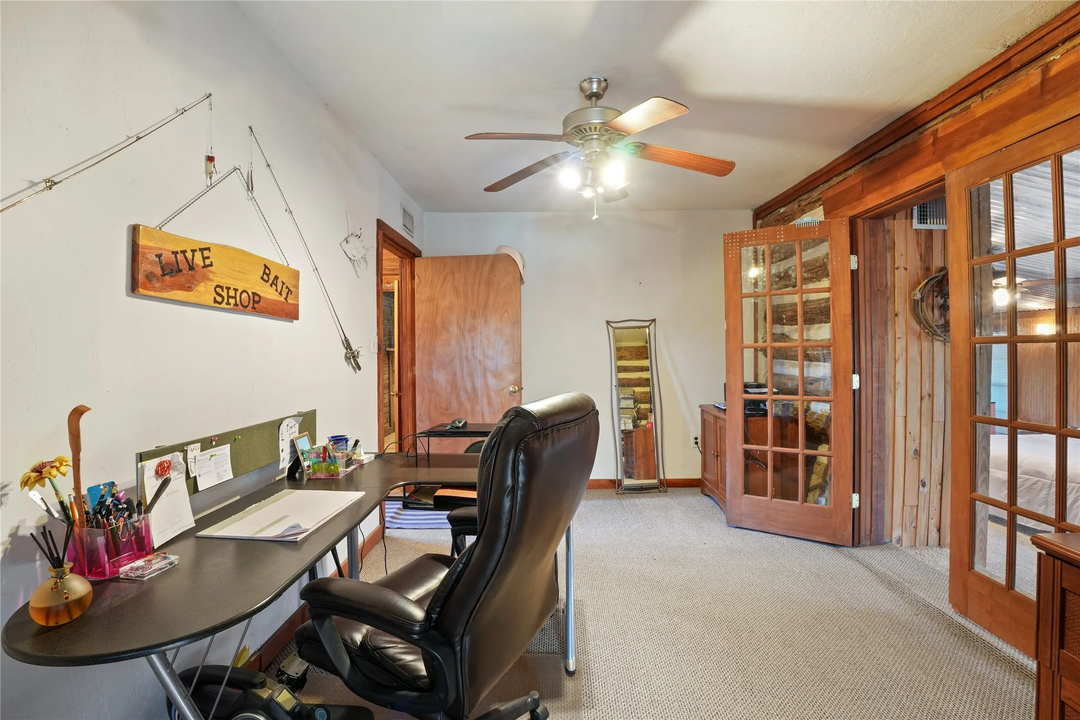 Neutral carpet flooring, natural wood doors, and a ceiling fan with integrated lighting