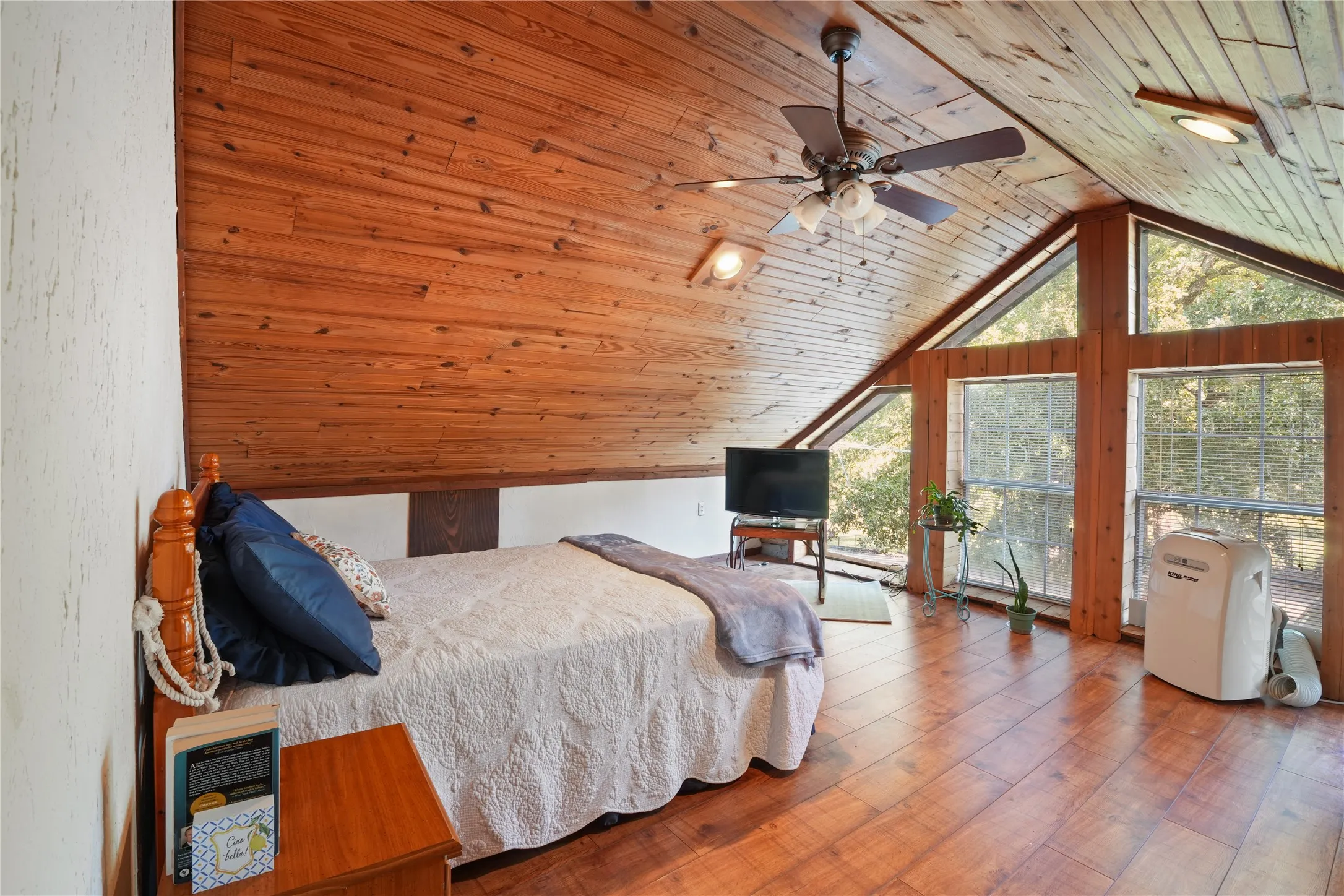 Wood-finish flooring, vaulted wood-paneled ceiling, ceiling fan, recessed lighting, and expansive windows