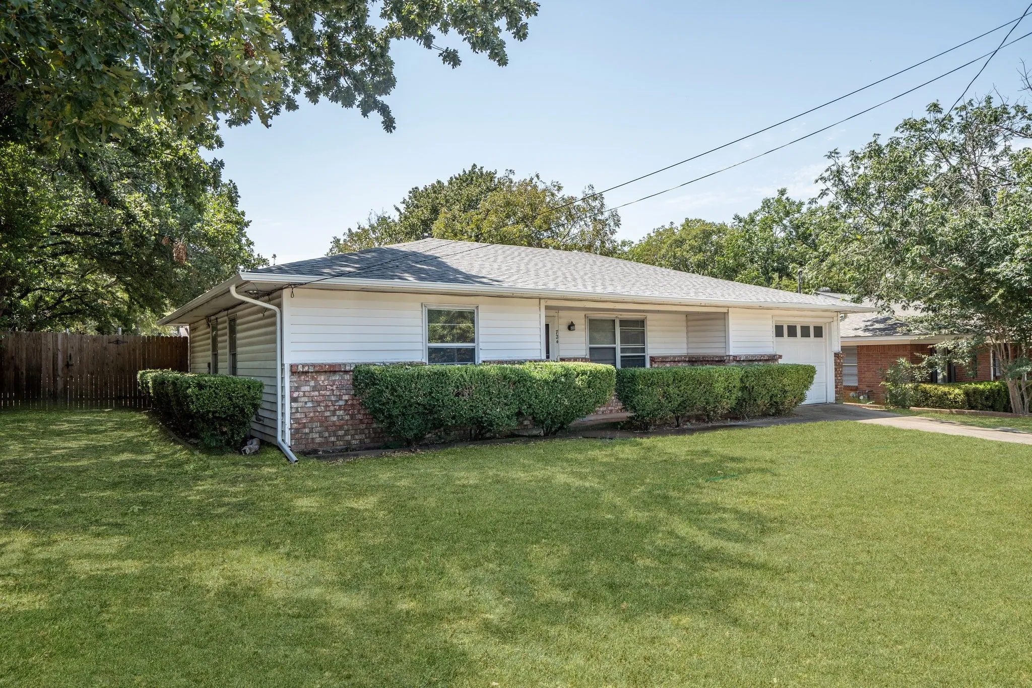 Ranch-style house featuring a garage and a front yard