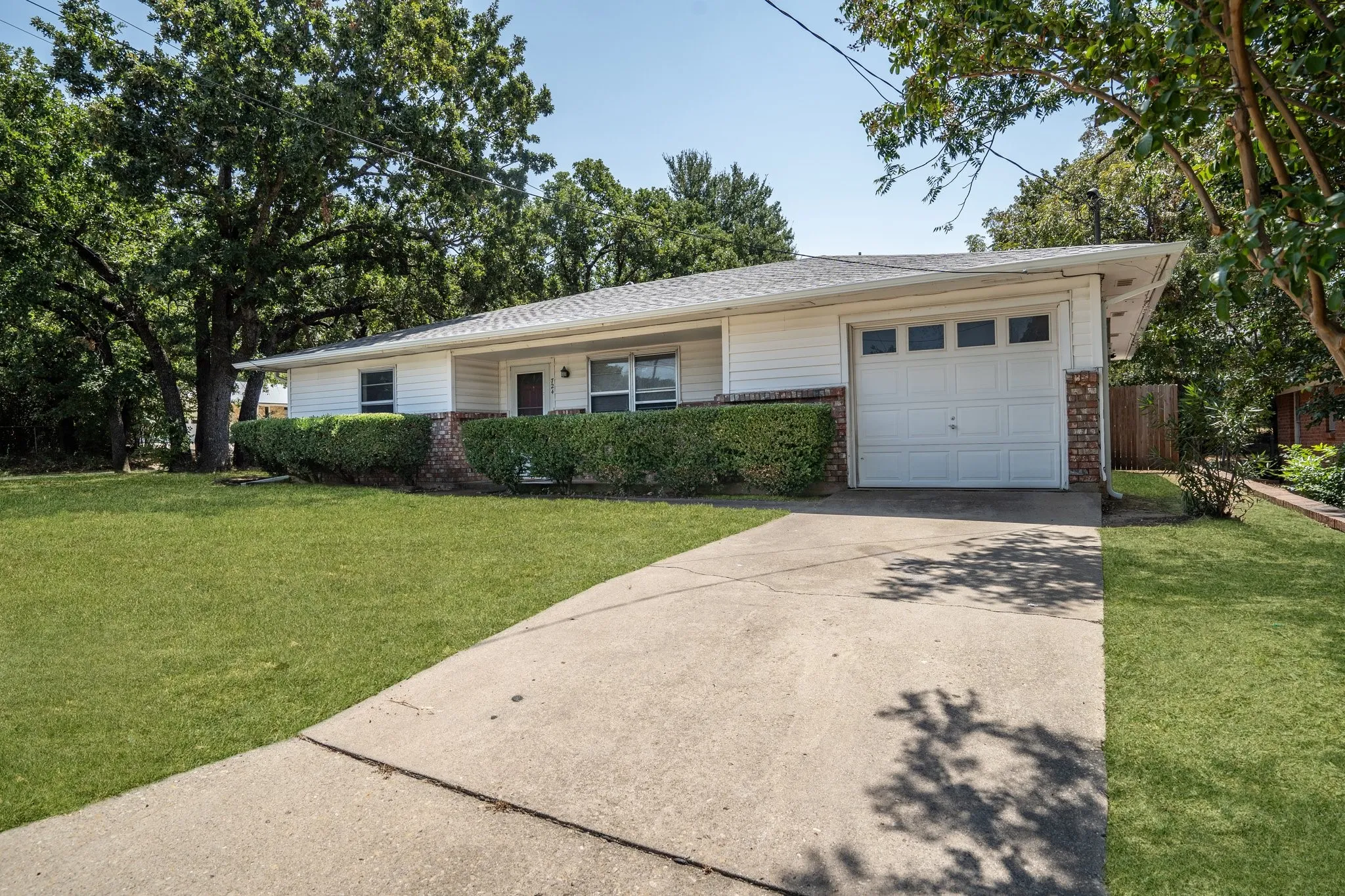 Ranch-style home featuring a front yard and a garage