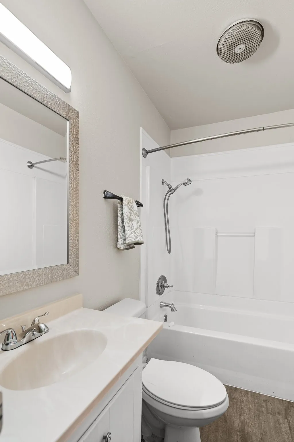 Full bathroom featuring tub / shower combination, vanity, hardwood / wood-style floors, and toilet