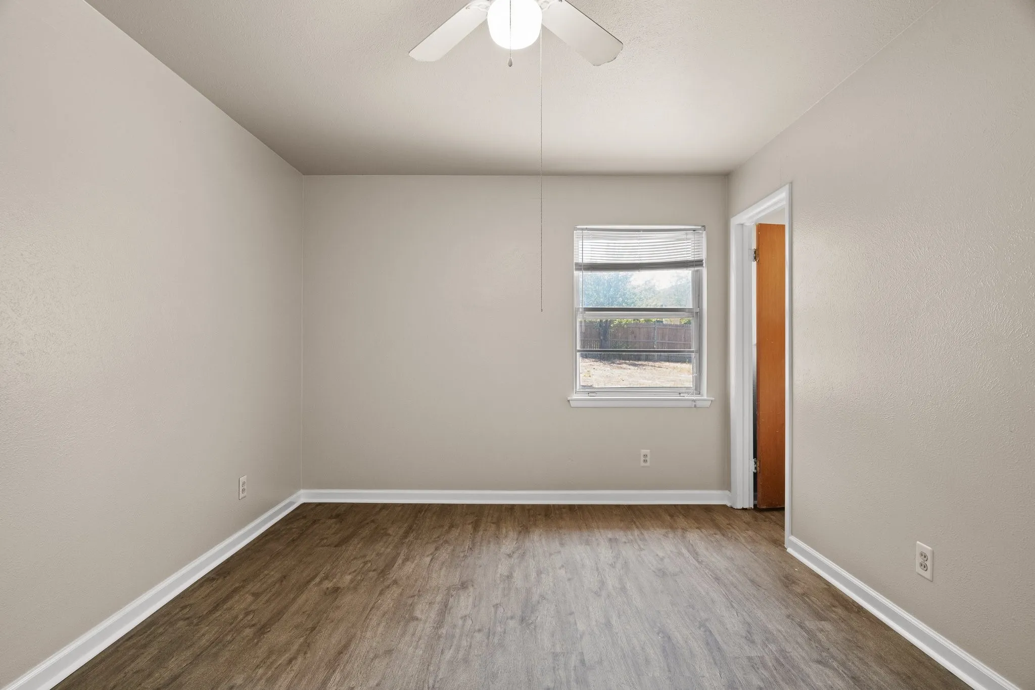 Empty room featuring hardwood / wood-style floors and ceiling fan