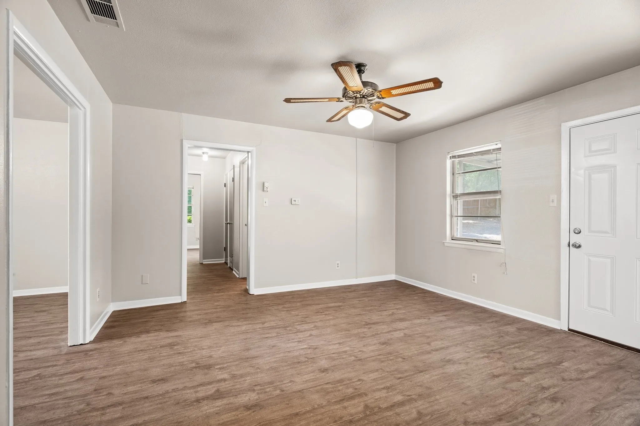 Empty room featuring ceiling fan and dark hardwood / wood-style floors