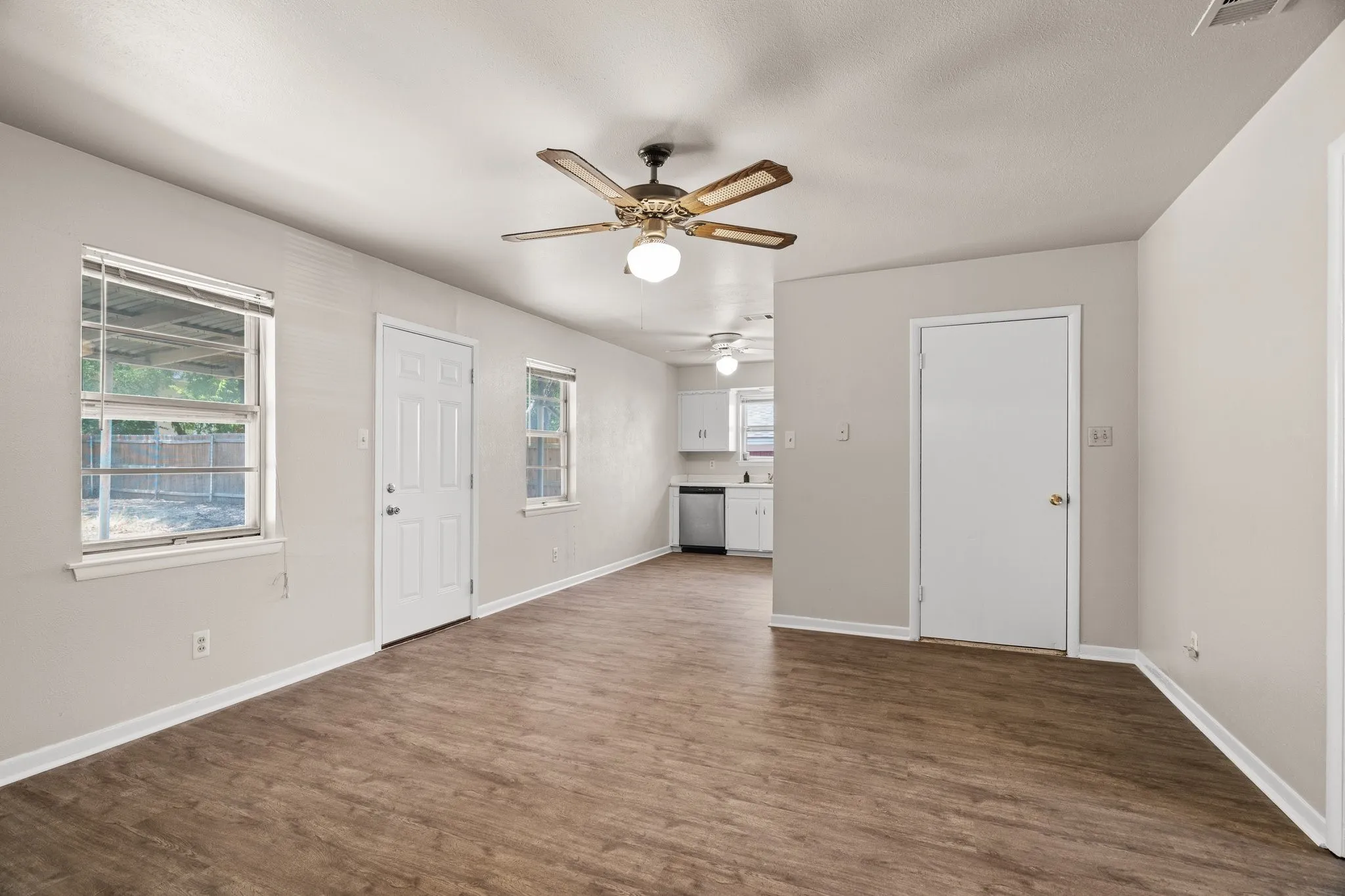 Entrance foyer with ceiling fan, a healthy amount of sunlight, and dark hardwood / wood-style flooring