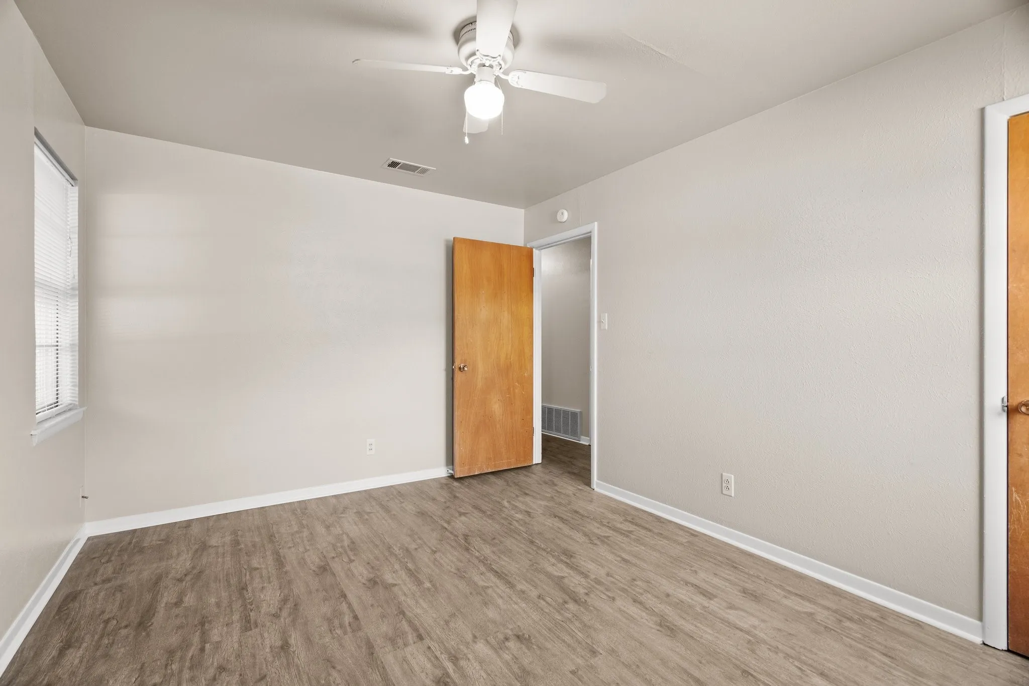 Spare room featuring ceiling fan and light hardwood / wood-style flooring