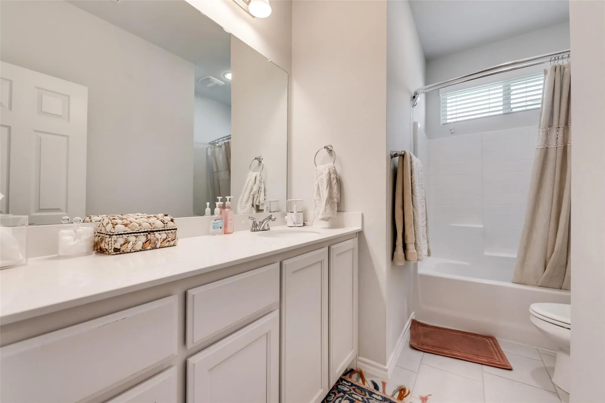 White vanity with shaker-style cabinetry, a white countertop, and an integrated rectangular sink