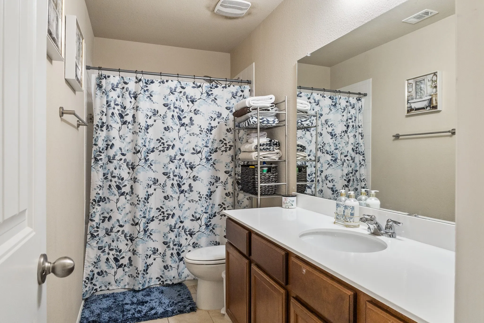 Bathroom vanity with a white countertop and integrated sink, complemented by a large wall-mounted mirror