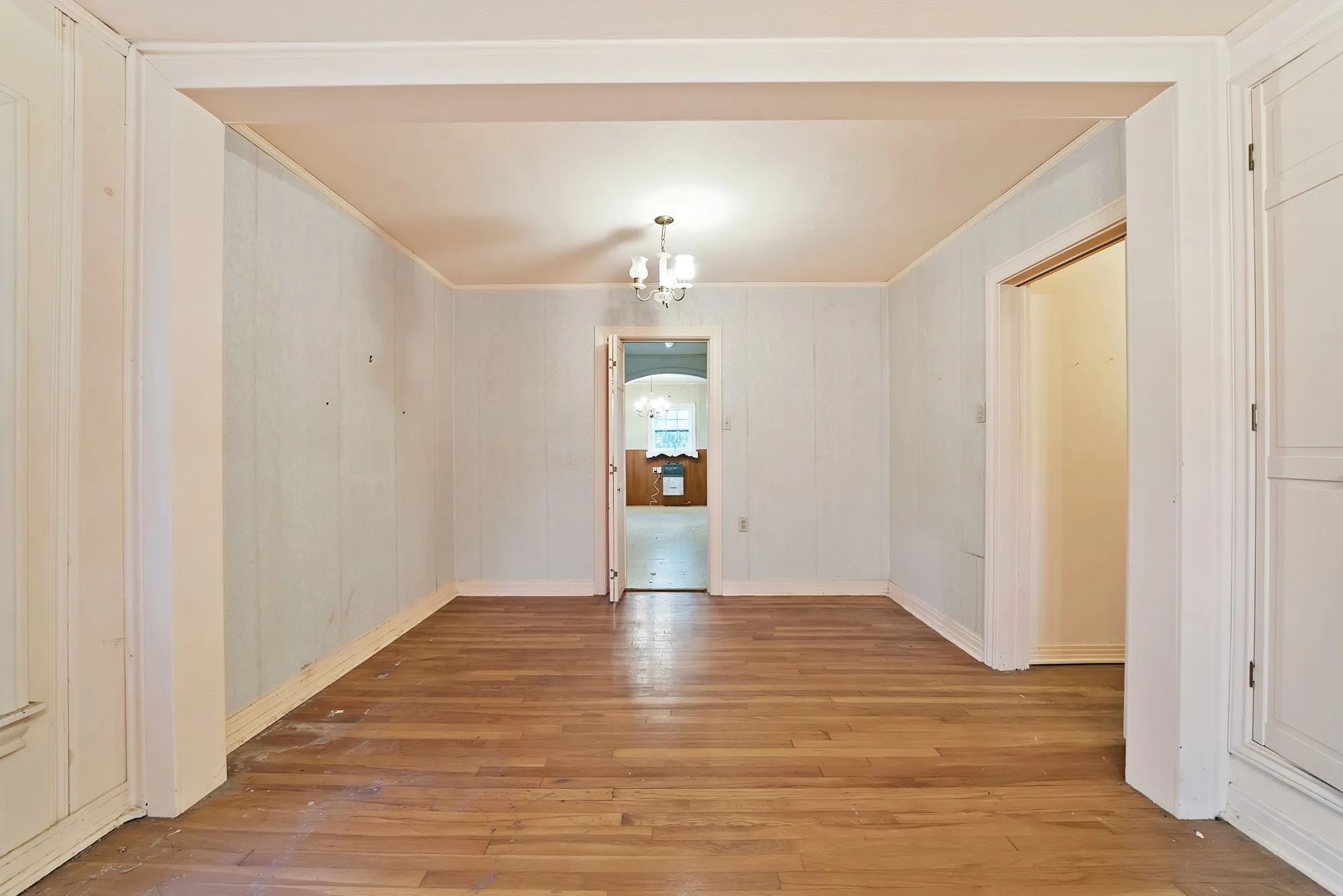 Hardwood flooring throughout, recessed archway, and overhead lighting fixture