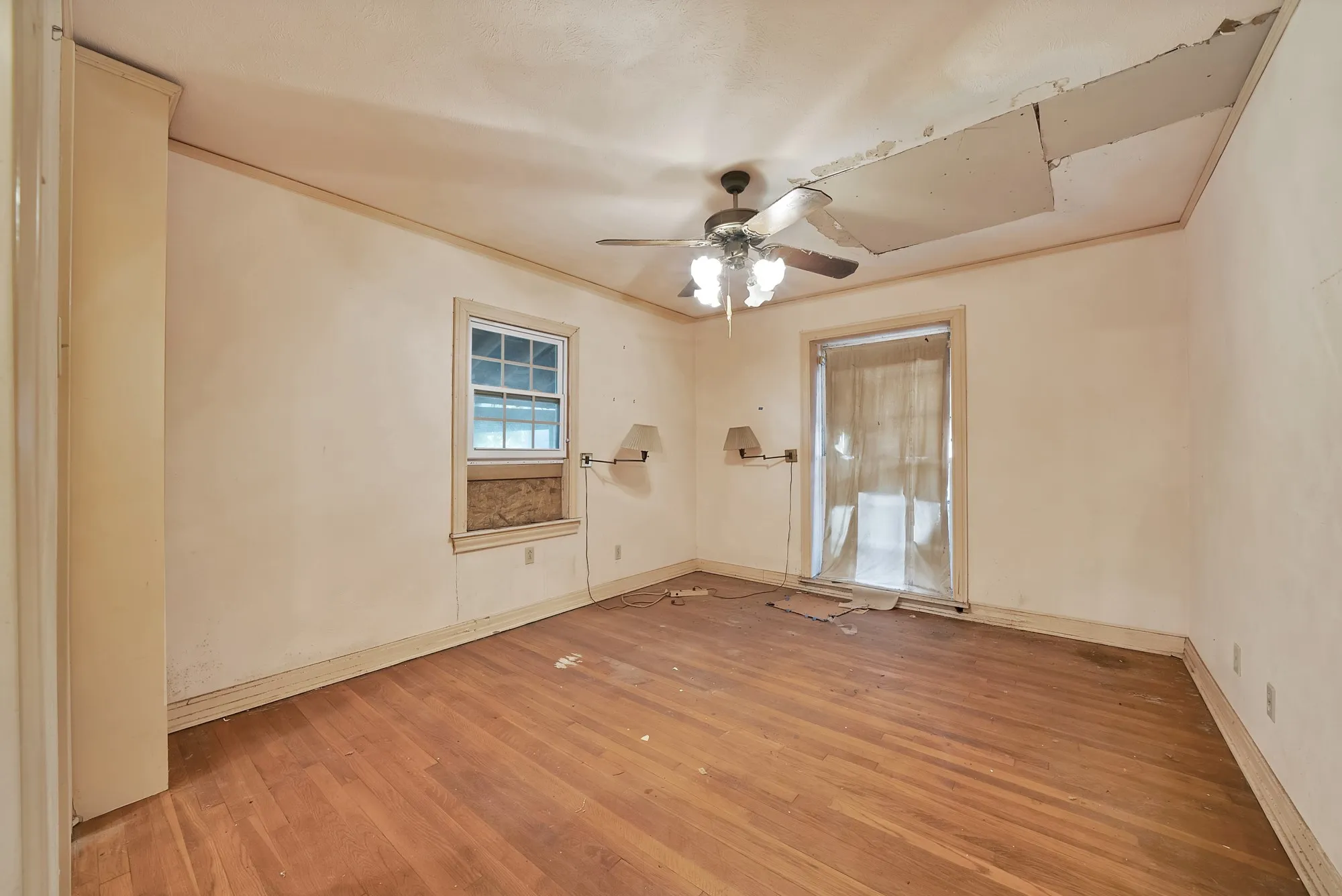 Wood-finish flooring with a ceiling fan light fixture and a multi-pane window