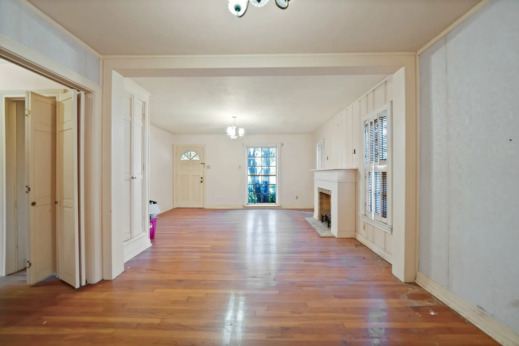 Hardwood flooring throughout, a fireplace with mantel, double-hung windows, and bifold closet doors