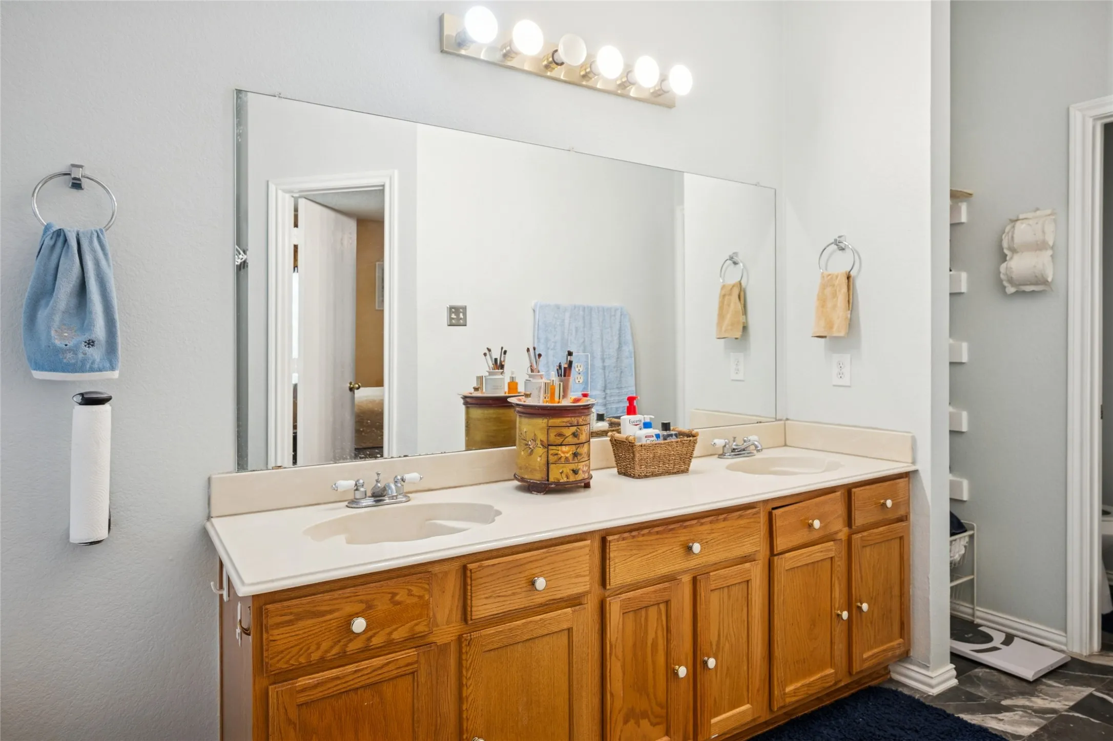 Dual vanity with integrated sinks, wood-finish cabinetry, and a full-width mirror