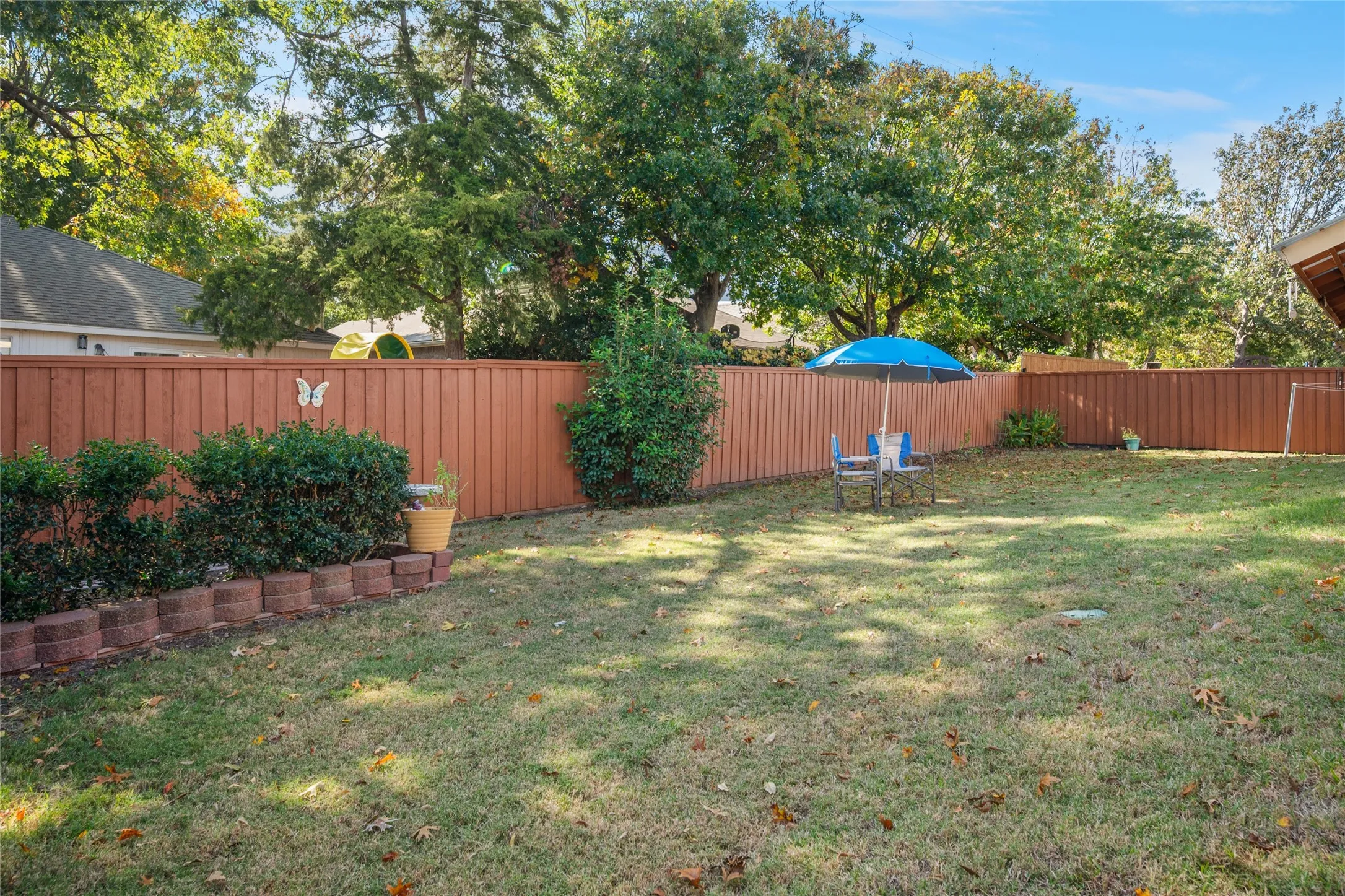 Expansive green lawn with a privacy fence