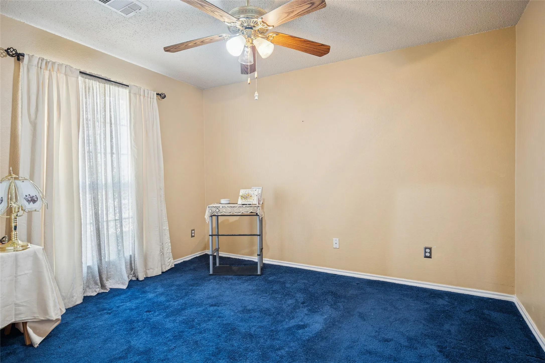 Room with a window, ceiling fan, and carpeting