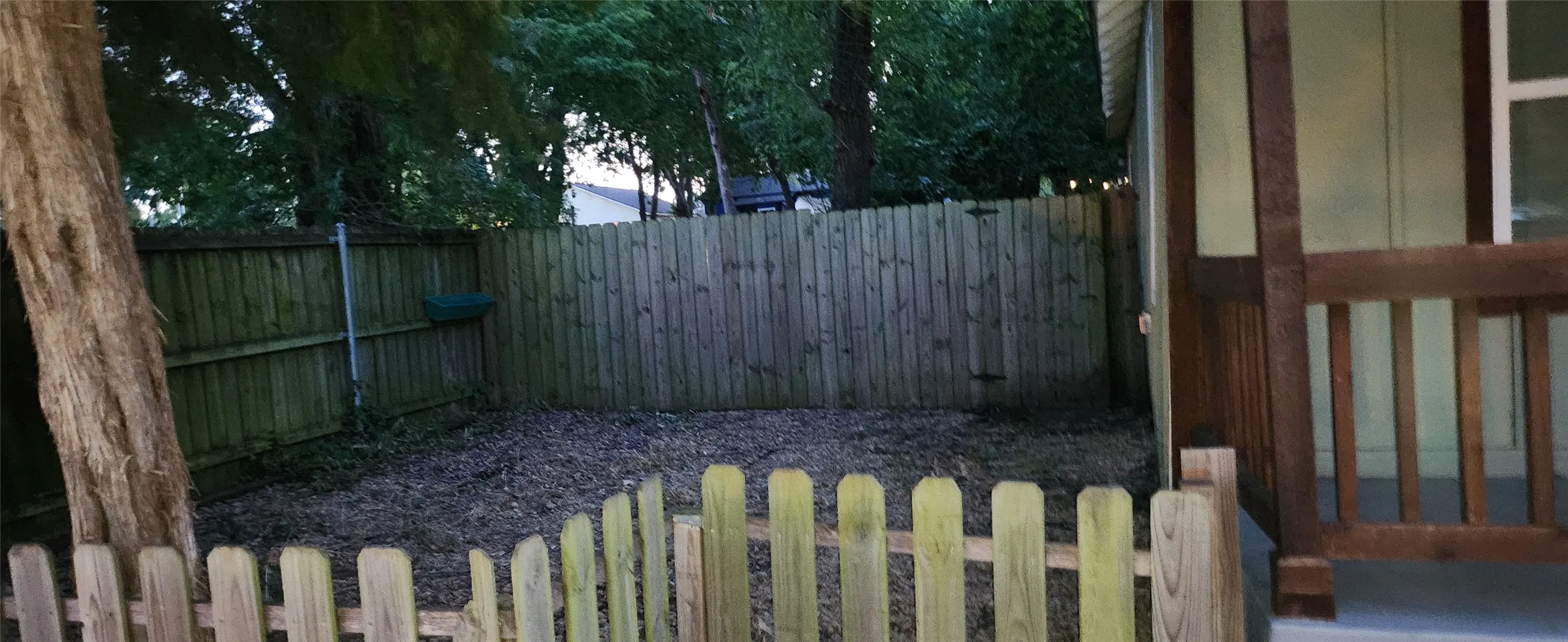 Fenced yard area with a small wooden picket fence and a full-height privacy​​‌​​​​‌​​‌‌​‌‌​​​‌‌​‌​‌​‌​​​‌​​ fence