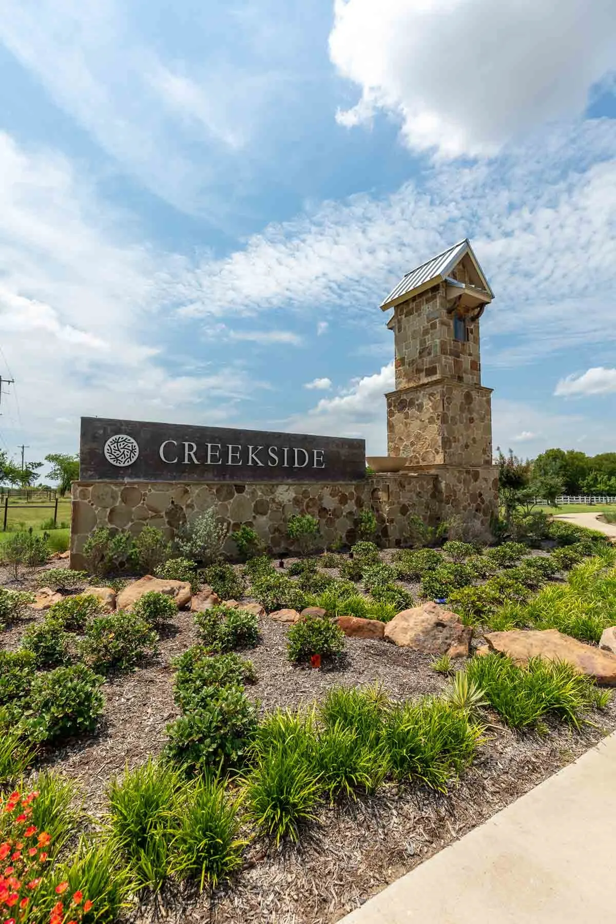 Stone-clad entry signage featuring a decorative tower