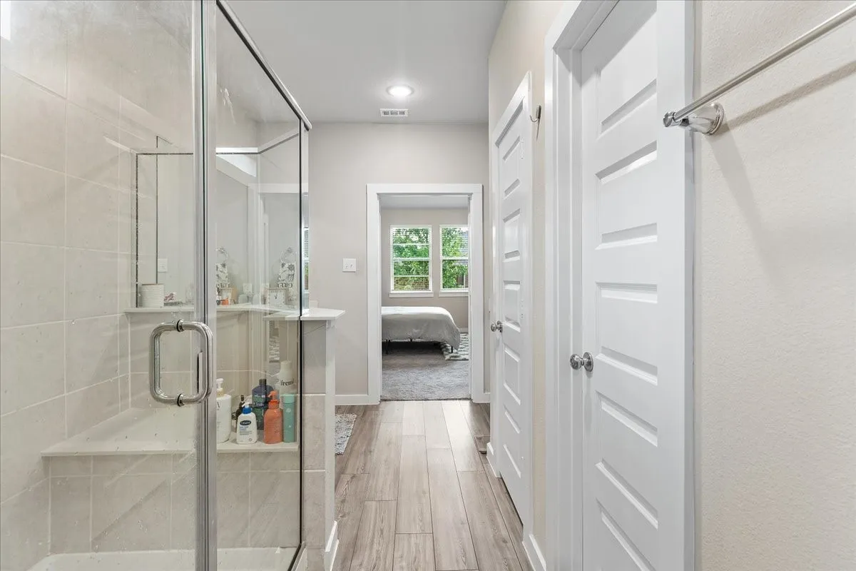 Glass-enclosed shower with a built-in bench and tiled walls