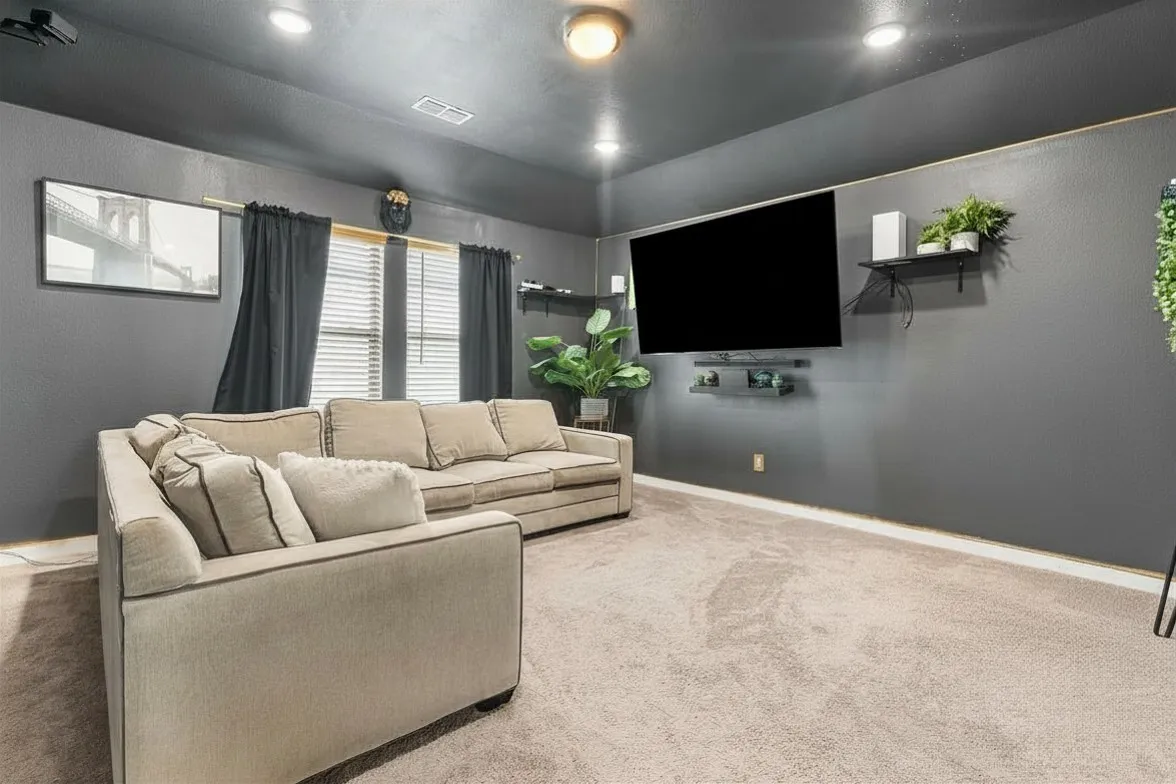 Recessed lighting, wall-mounted shelving, window with blinds, wall-mounted television, and carpeted flooring