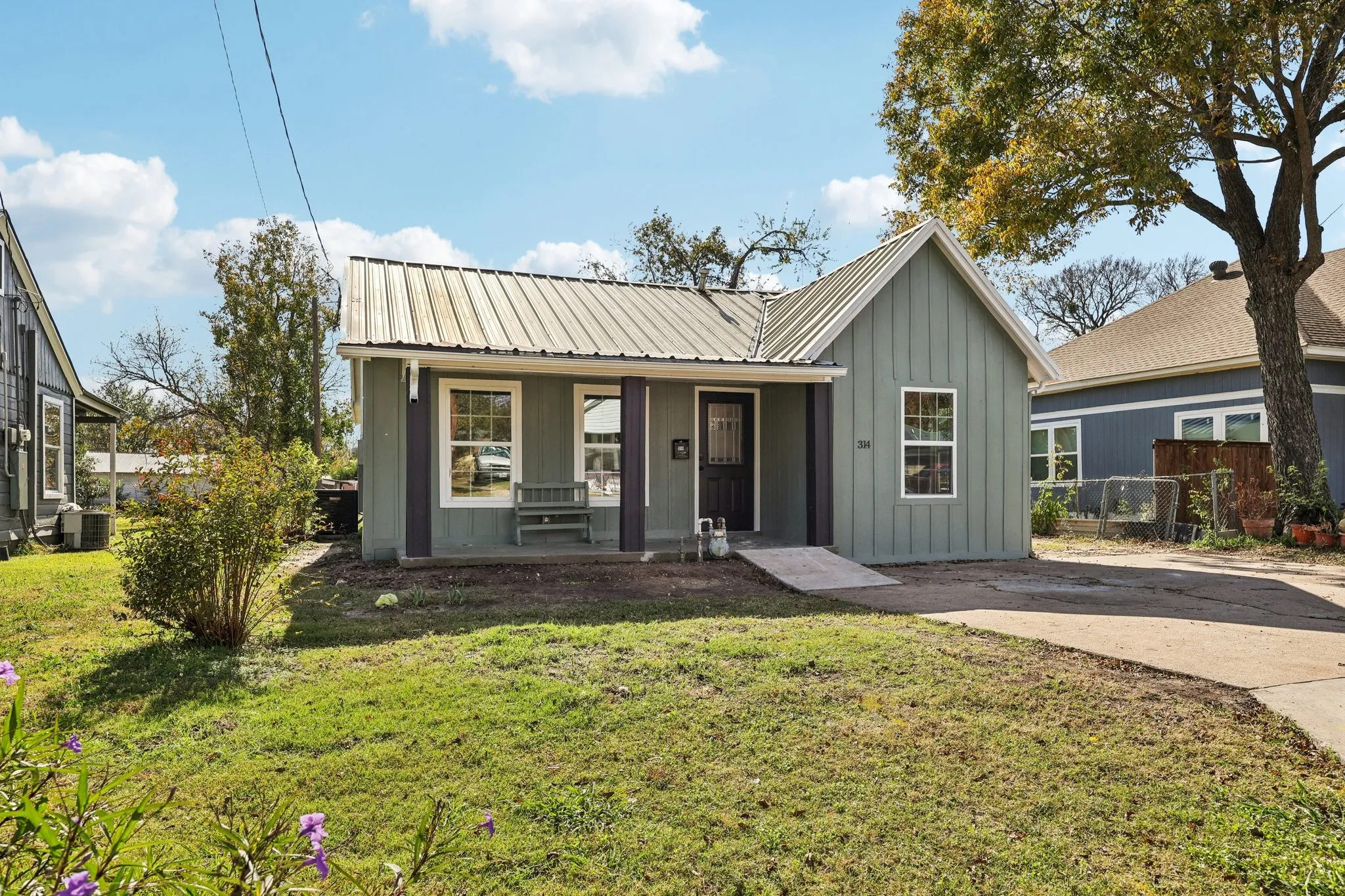 Single-story residence featuring a gray metal roof and light green siding