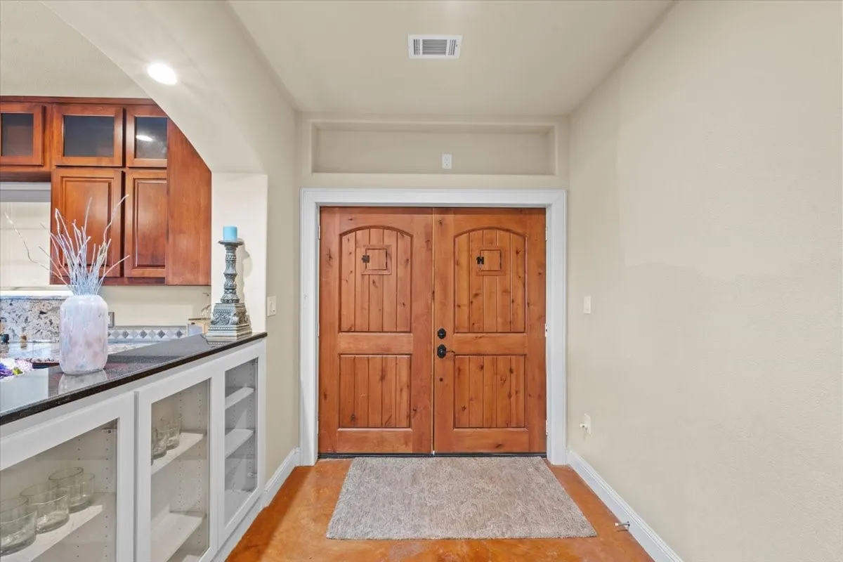 Front entry with glass encased cabinets at 3601 Oak Cir, Weatherford, TX 76088 - 3664 sq ft on 2.92 acres with a 2600 sq ft workshop