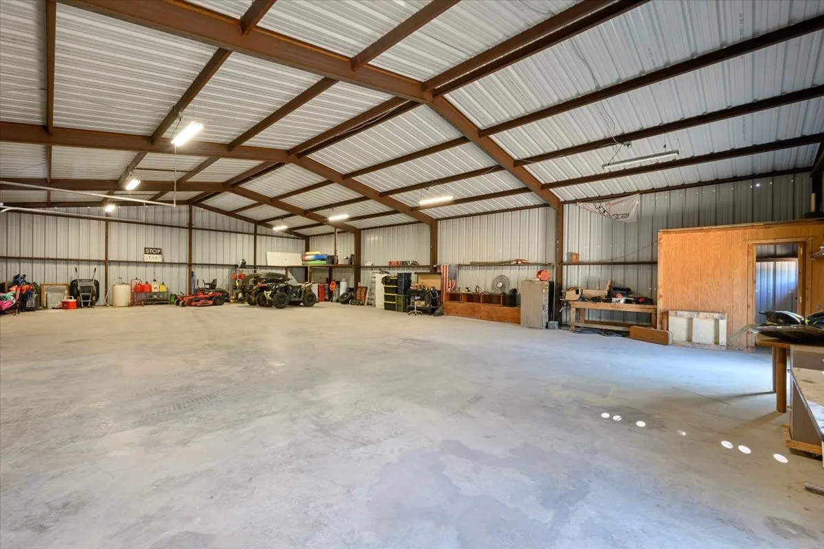 Expansive 2600 sq ft workshop equipped with set of swing doors and an overhead door at 3601 Oak Cir, Weatherford, TX -76088 on 2.92 acres