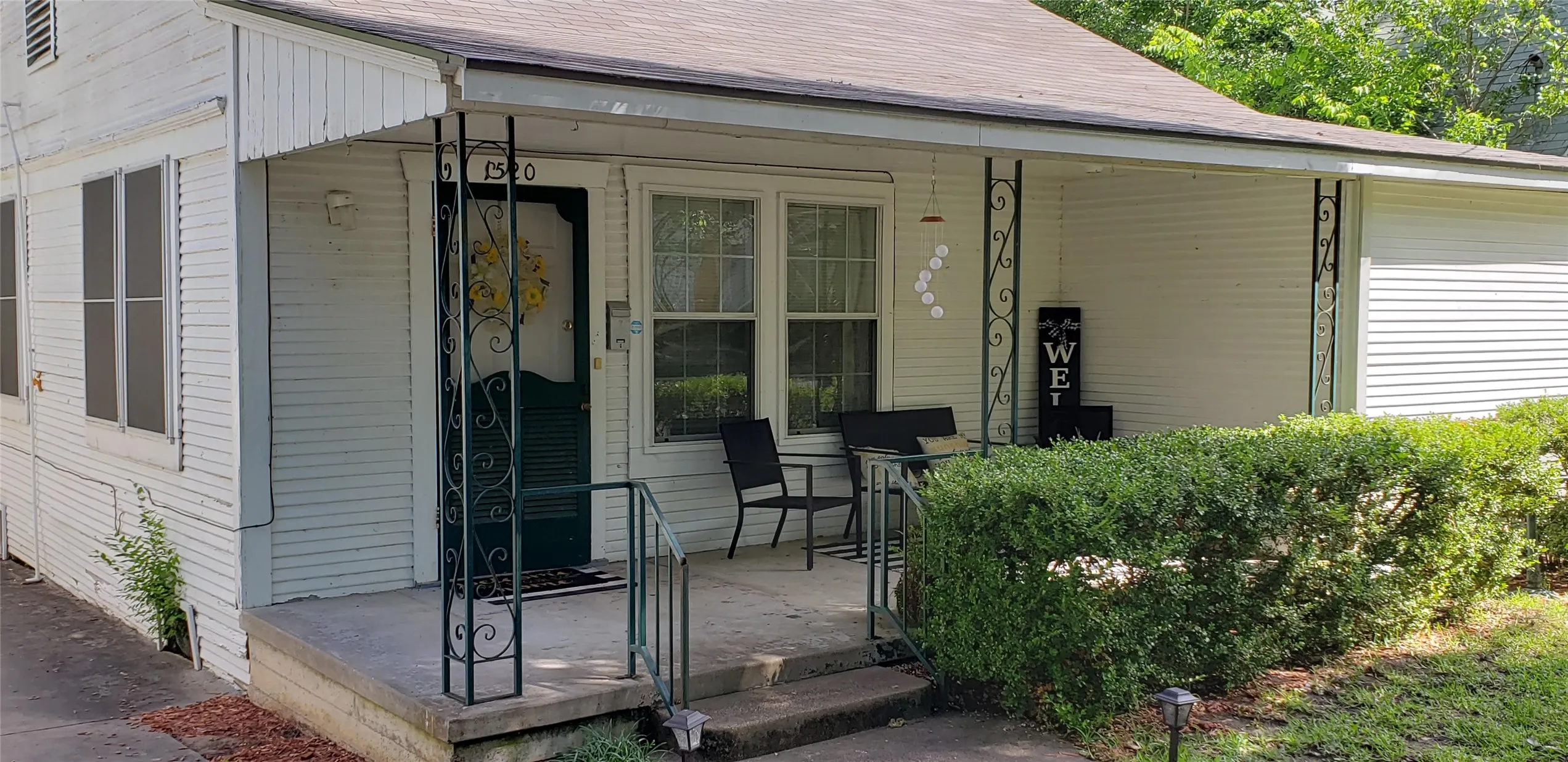 Front exterior with white horizontal siding and a covered porch