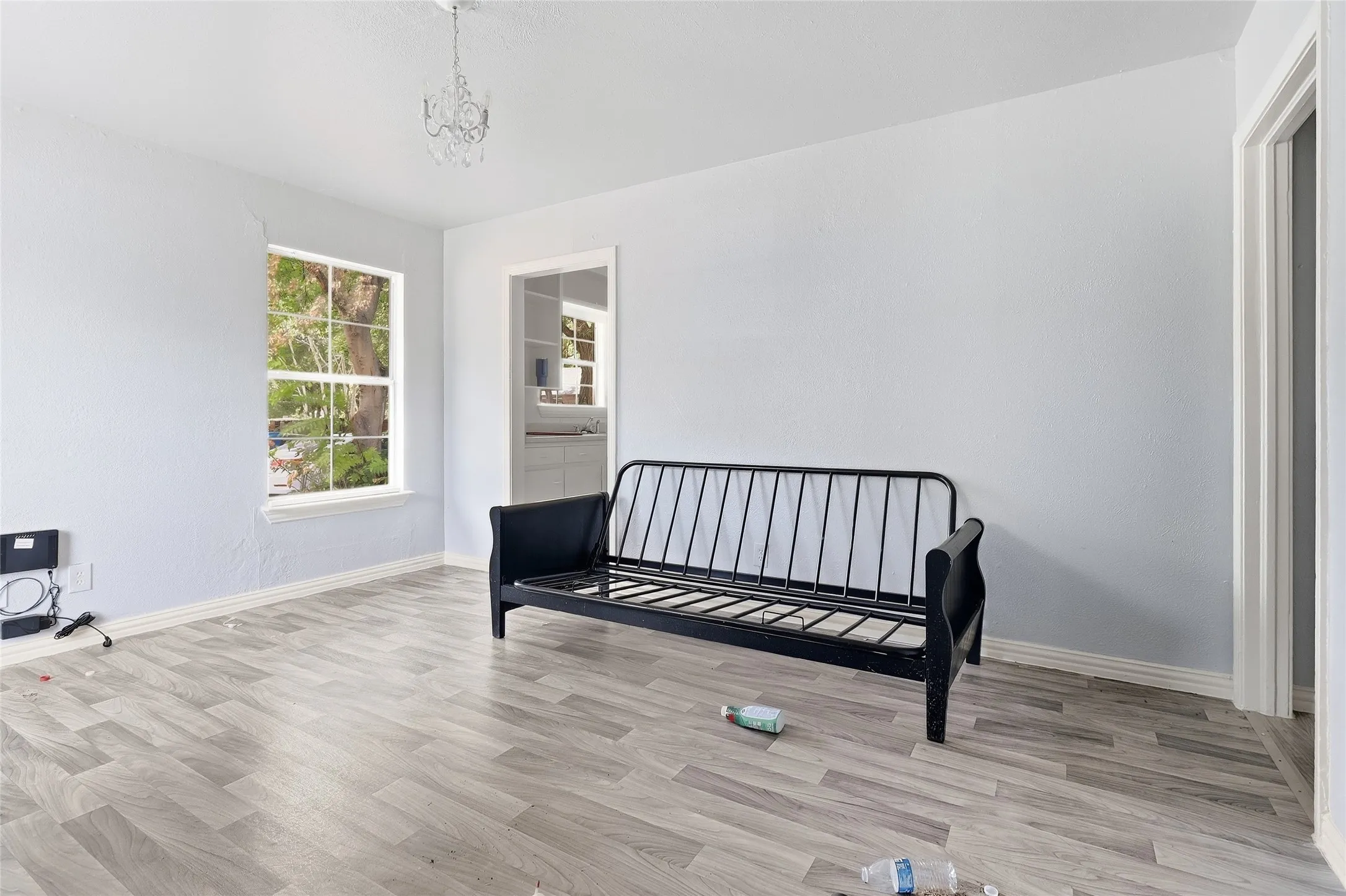 Light wood-finish flooring, white trim, and a window with natural light