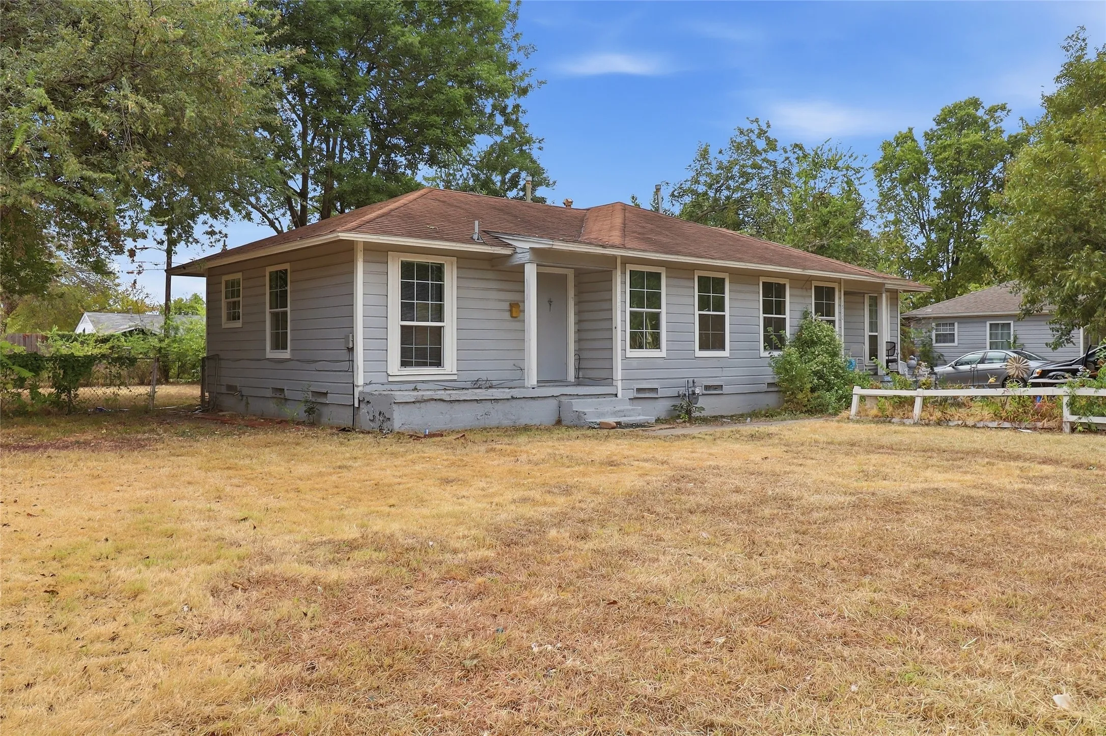 Single-story property featuring light gray siding and a composition shingle roof