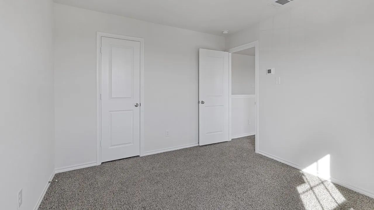Neutral wall tones, gray carpeting, white trim, and white doors