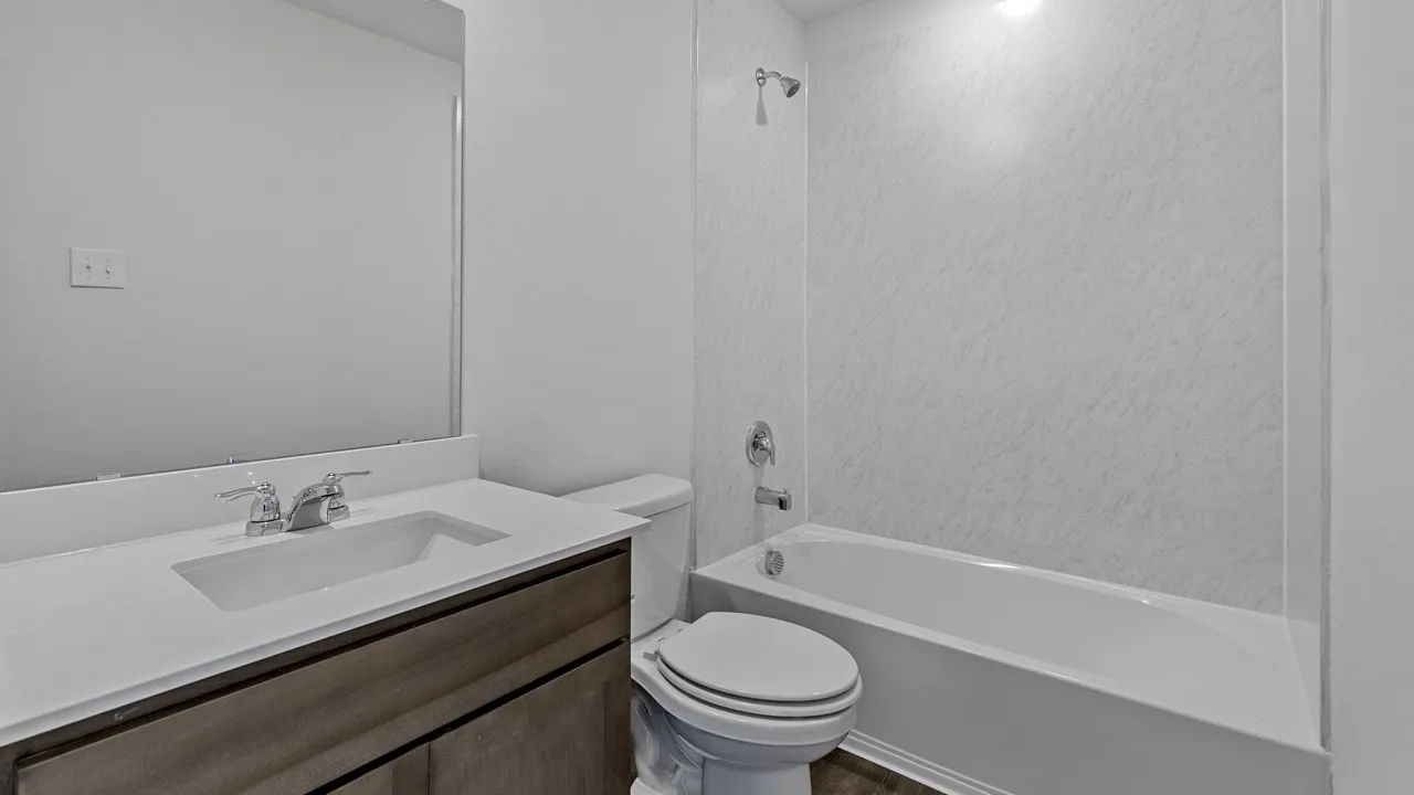 Bathroom with a wood-finish vanity, integrated sink, and chrome fixtures