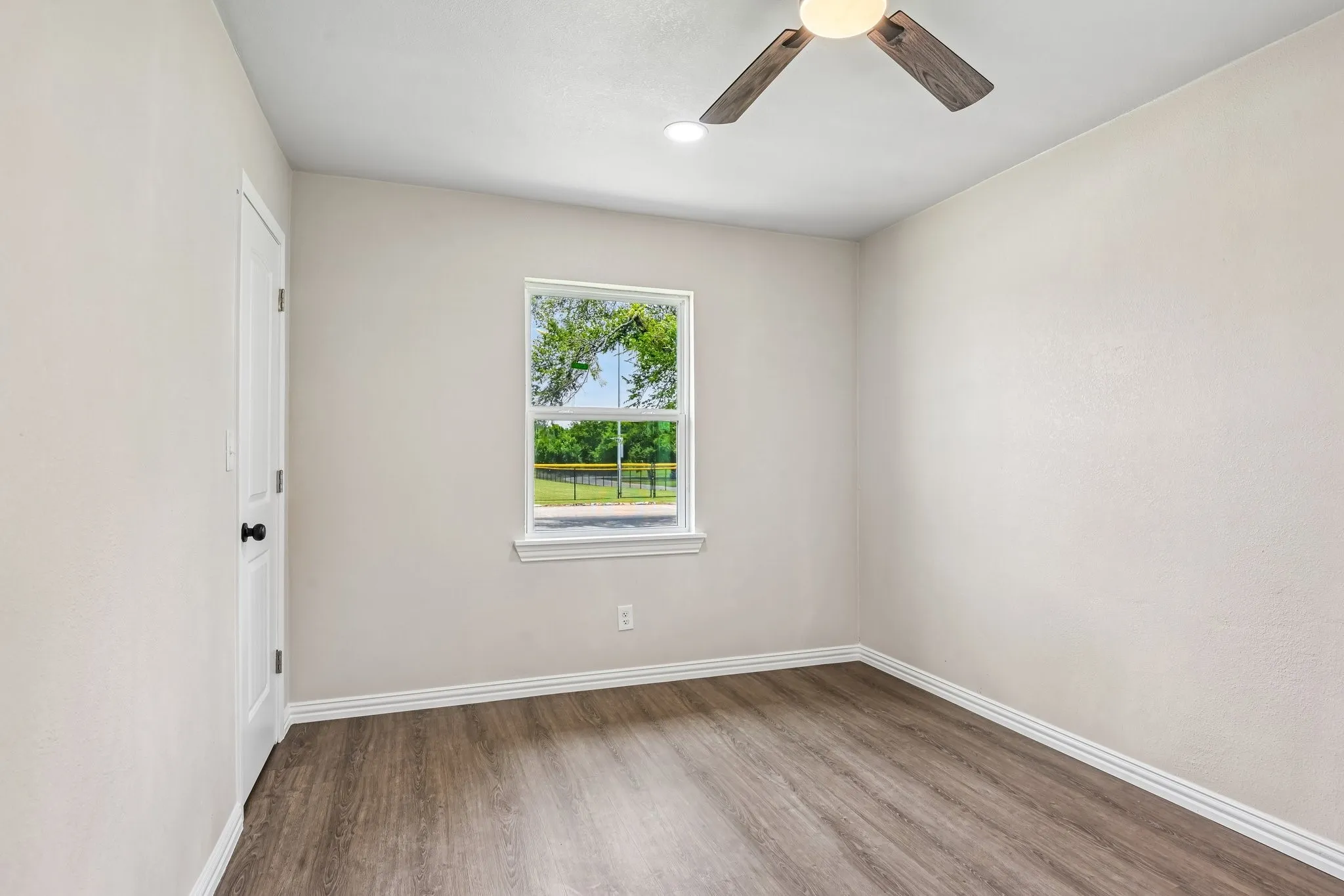 Interior room featuring wood-finish flooring, a ceiling fan with light, and recessed lighting