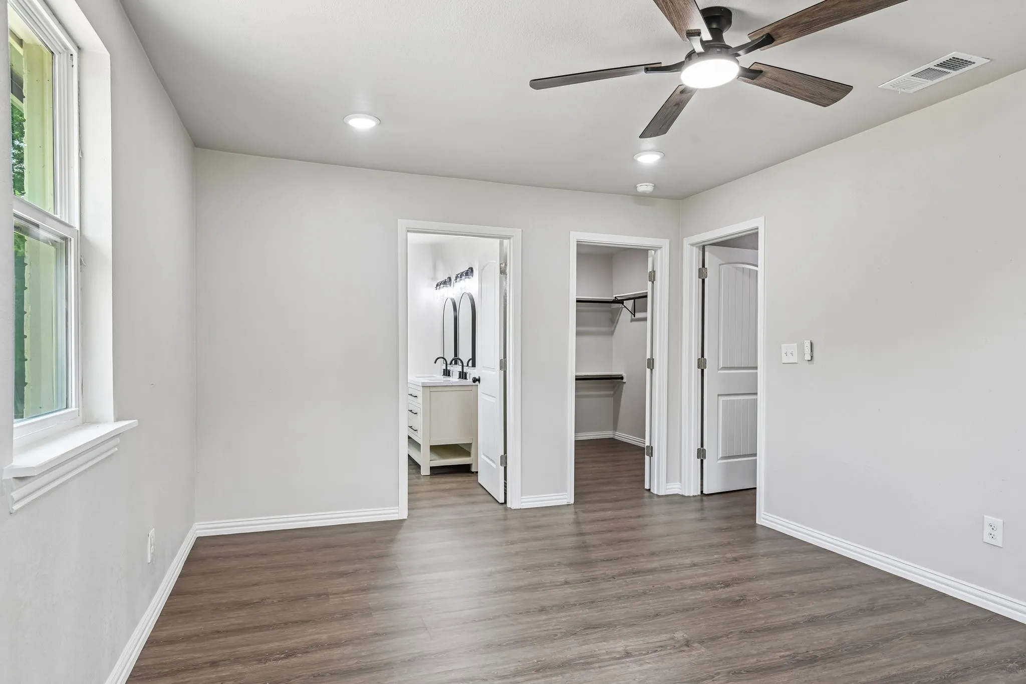Spacious room featuring wood-finish flooring, recessed lighting, and a ceiling fan
