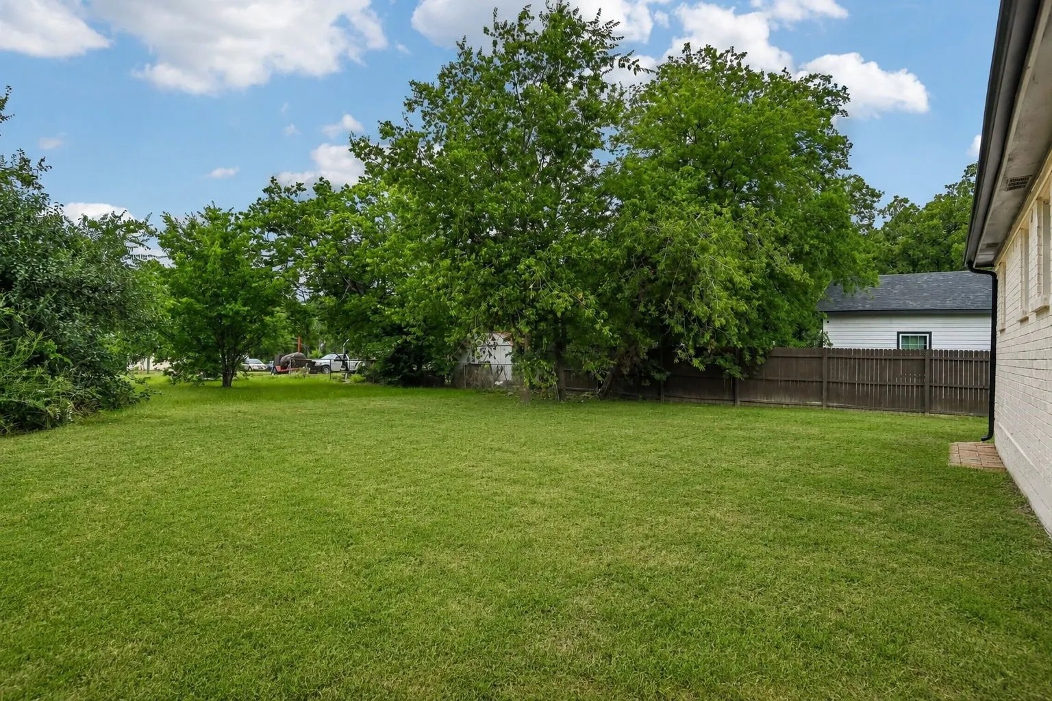 Expansive green lawn with a privacy fence