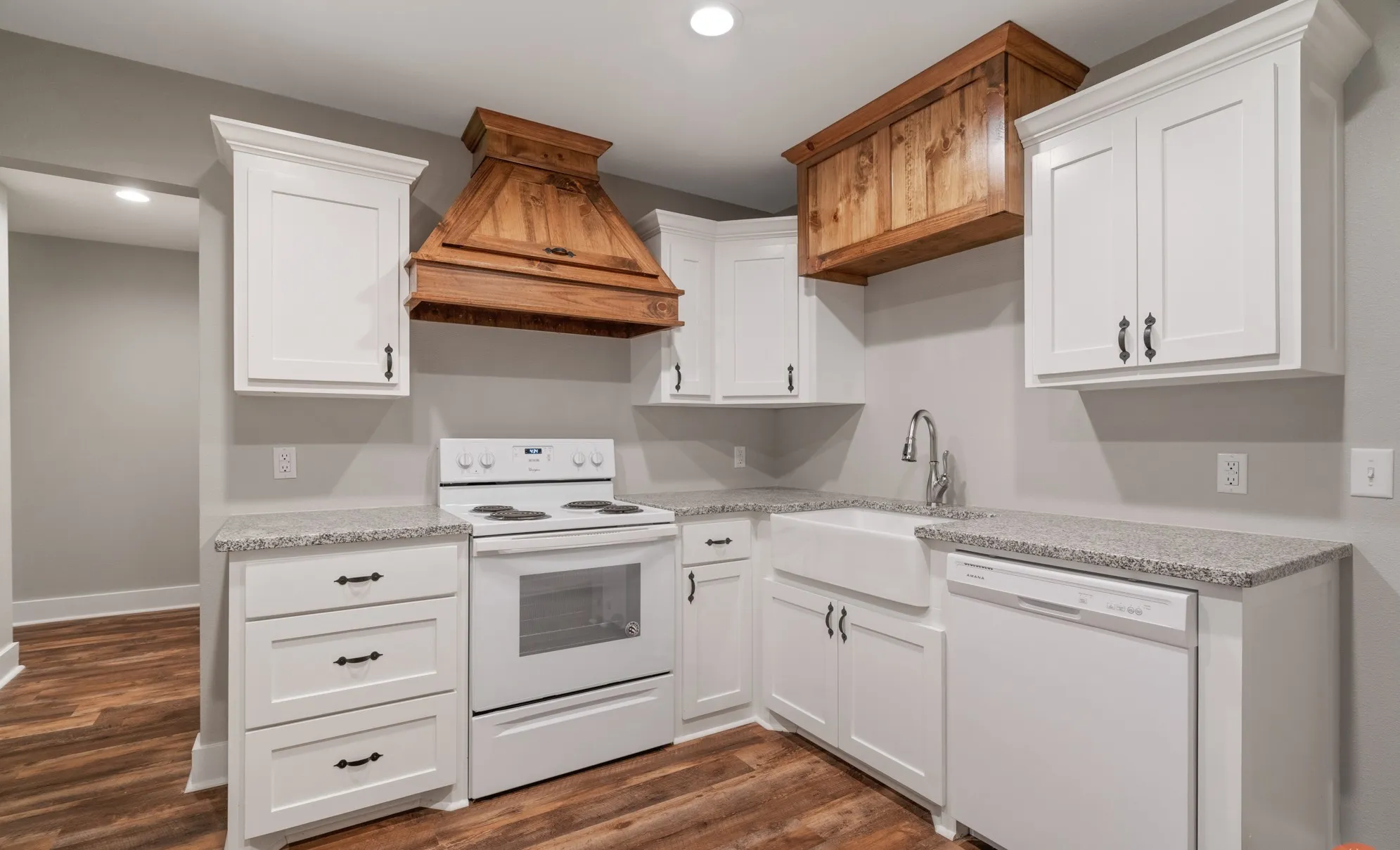 Kitchen with white shaker cabinetry, granite countertops, wood-finish flooring, a farmhouse sink, and a custom wood range hood