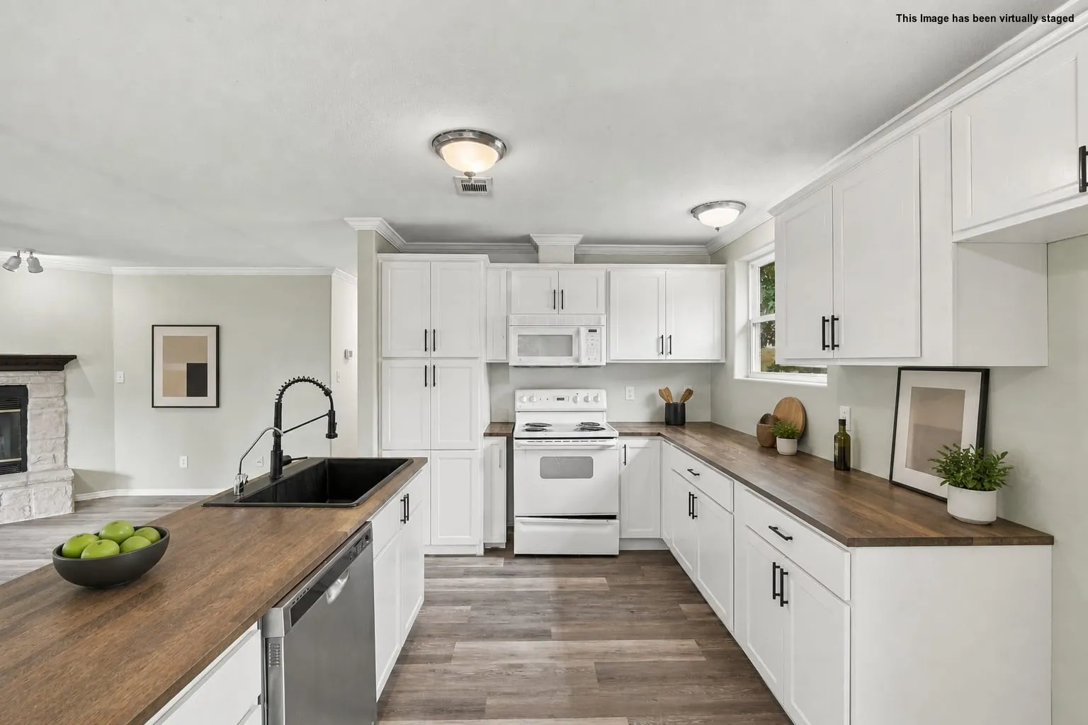 Virtually staged. White cabinetry with matte black hardware, wood-finish countertops, stainless steel dishwasher, and a black sink with a gooseneck faucet