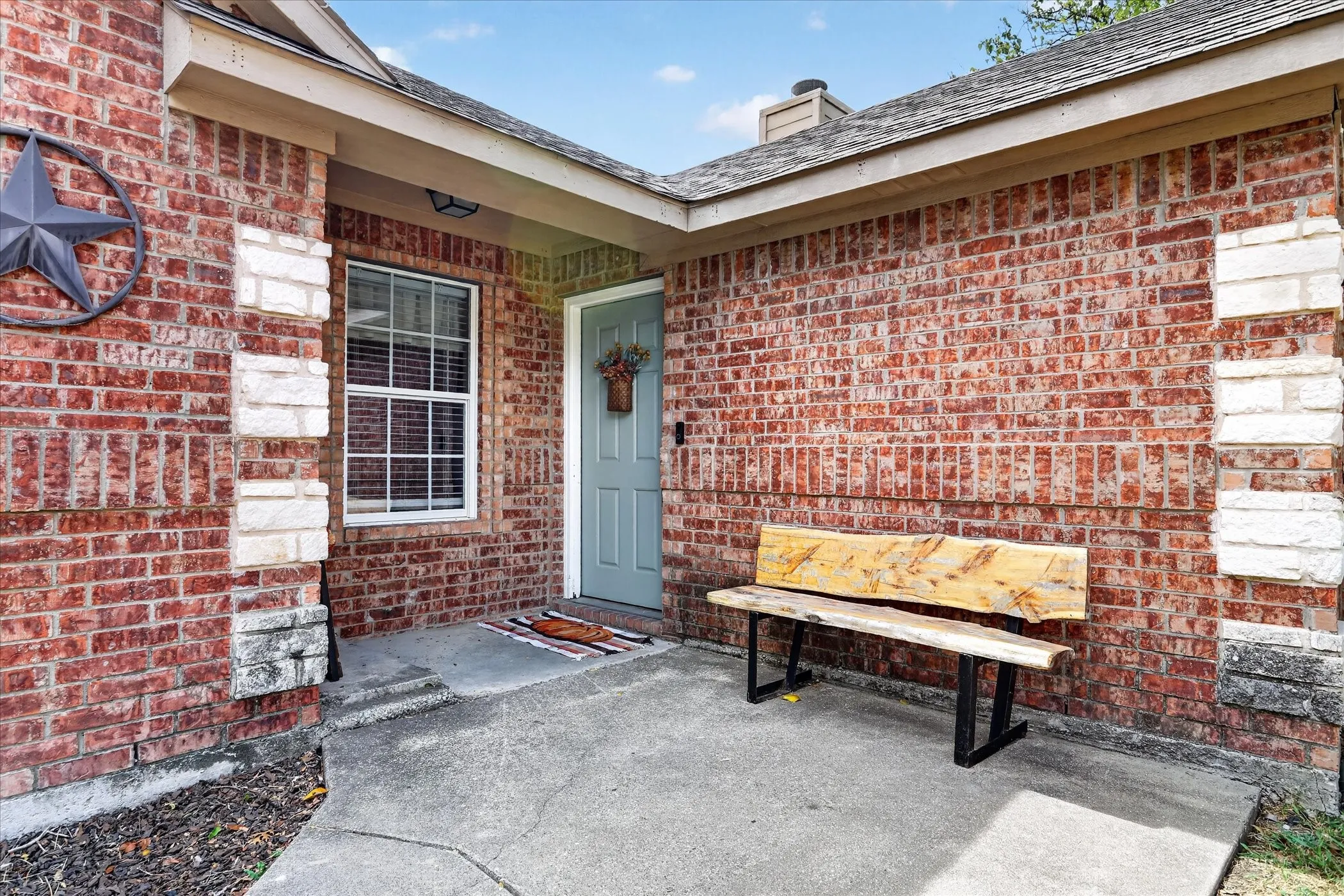 Brick exterior with stone accents, a covered entry, and a window with blinds