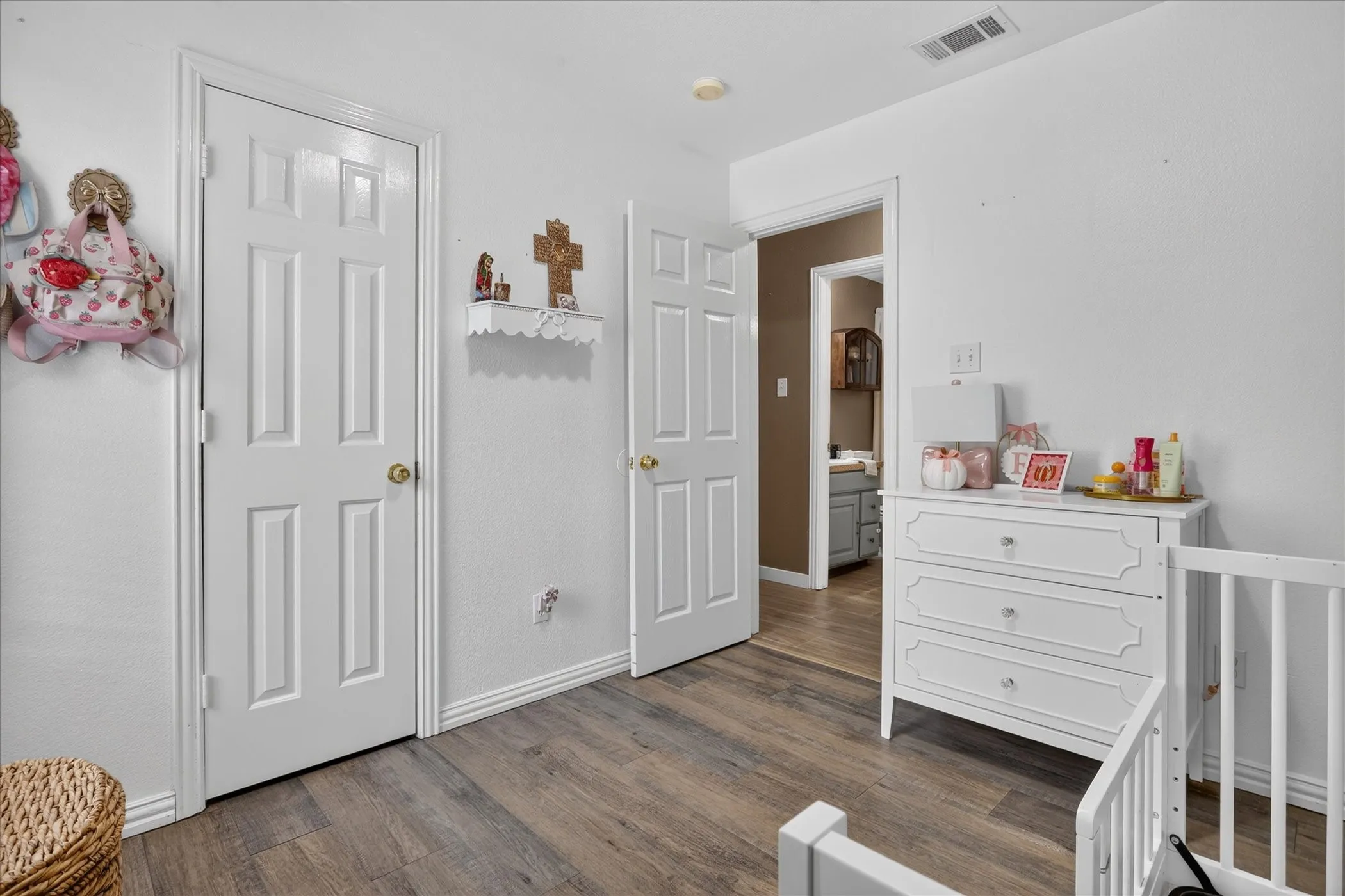 Wood-finish flooring with white baseboards and trim