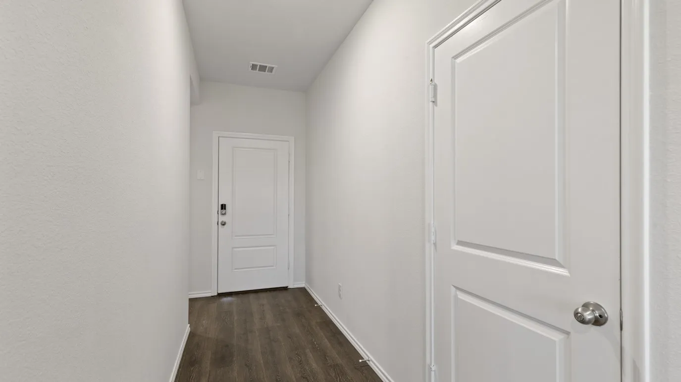 White interior walls, wood-finish flooring, white paneled doors, recessed ceiling vent, and a contemporary door lock