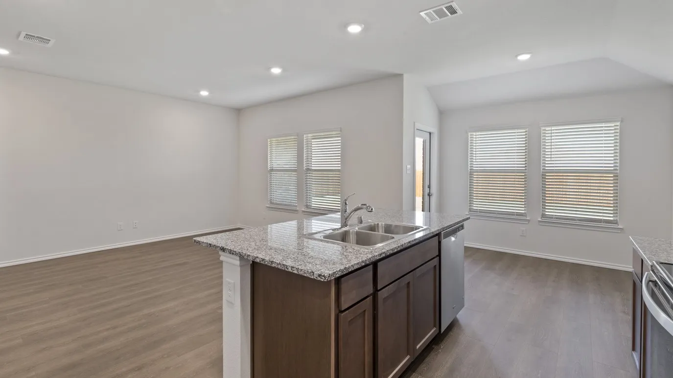 Kitchen island with granite countertop, stainless steel double basin sink, and integrated dishwasher